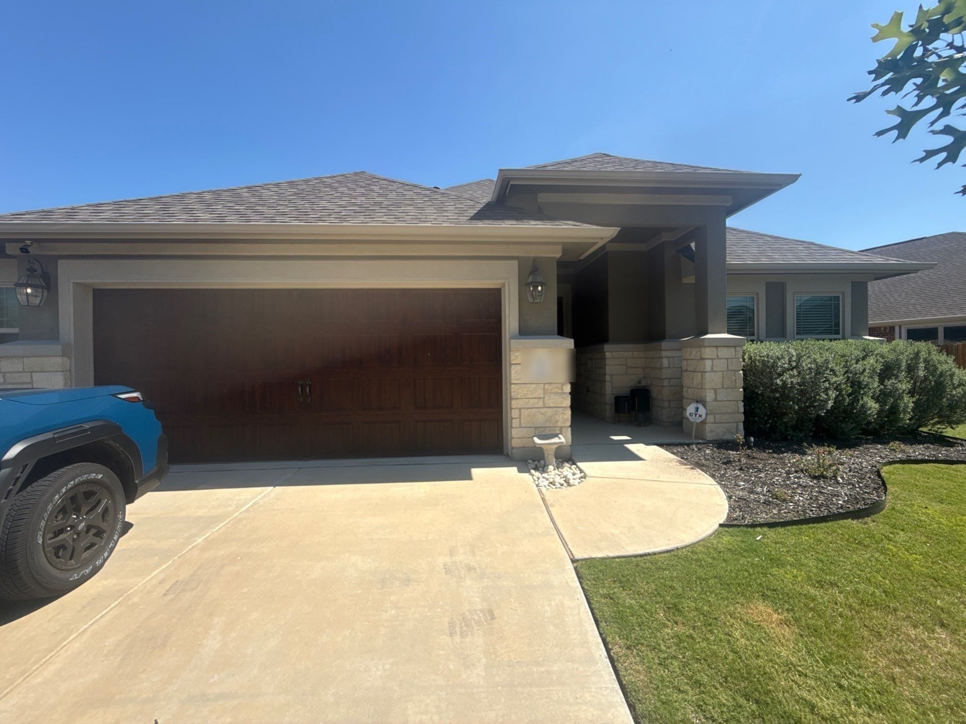 Single-story stone and stucco home on Hereford Loop in Hutto, TX ahead of exterior painting by Hill Country Painting