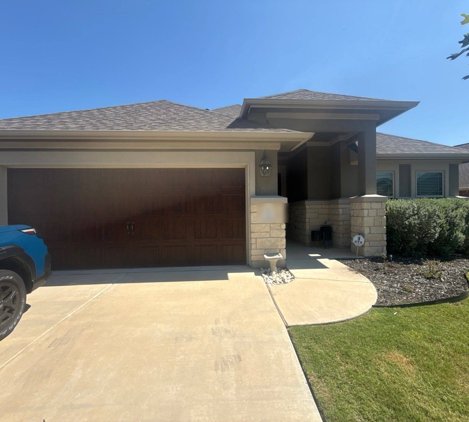 Single-story stone and stucco home on Hereford Loop in Hutto, TX ahead of exterior painting by Hill Country Painting