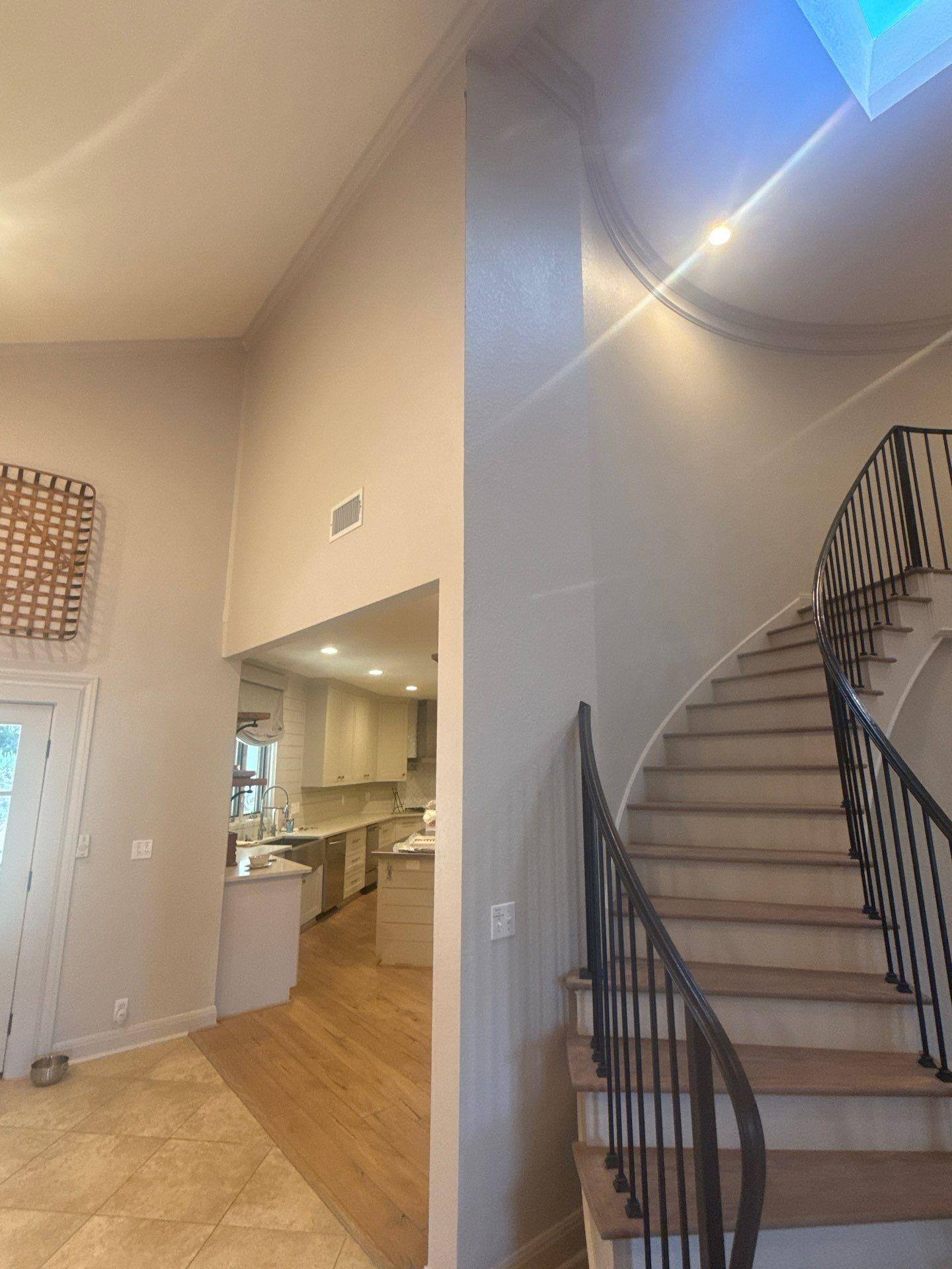 Entryway with curved staircase in a home on Challenger in Lakeway, TX ahead of an interior painting estimate by Hill Country Painting
