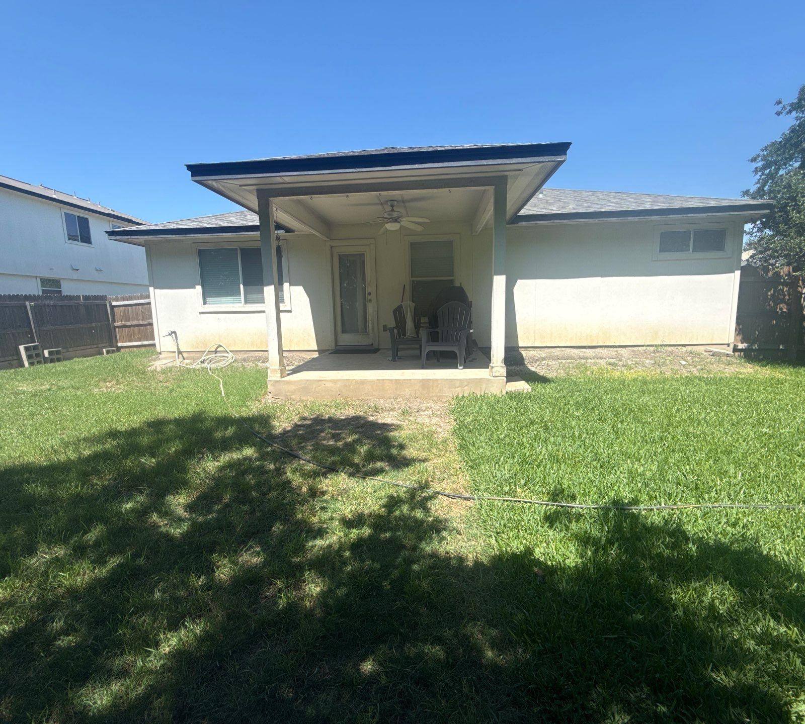Back exterior and covered patio of a home on Delby St in Hutto, TX ahead of exterior painting by Hill Country Painting