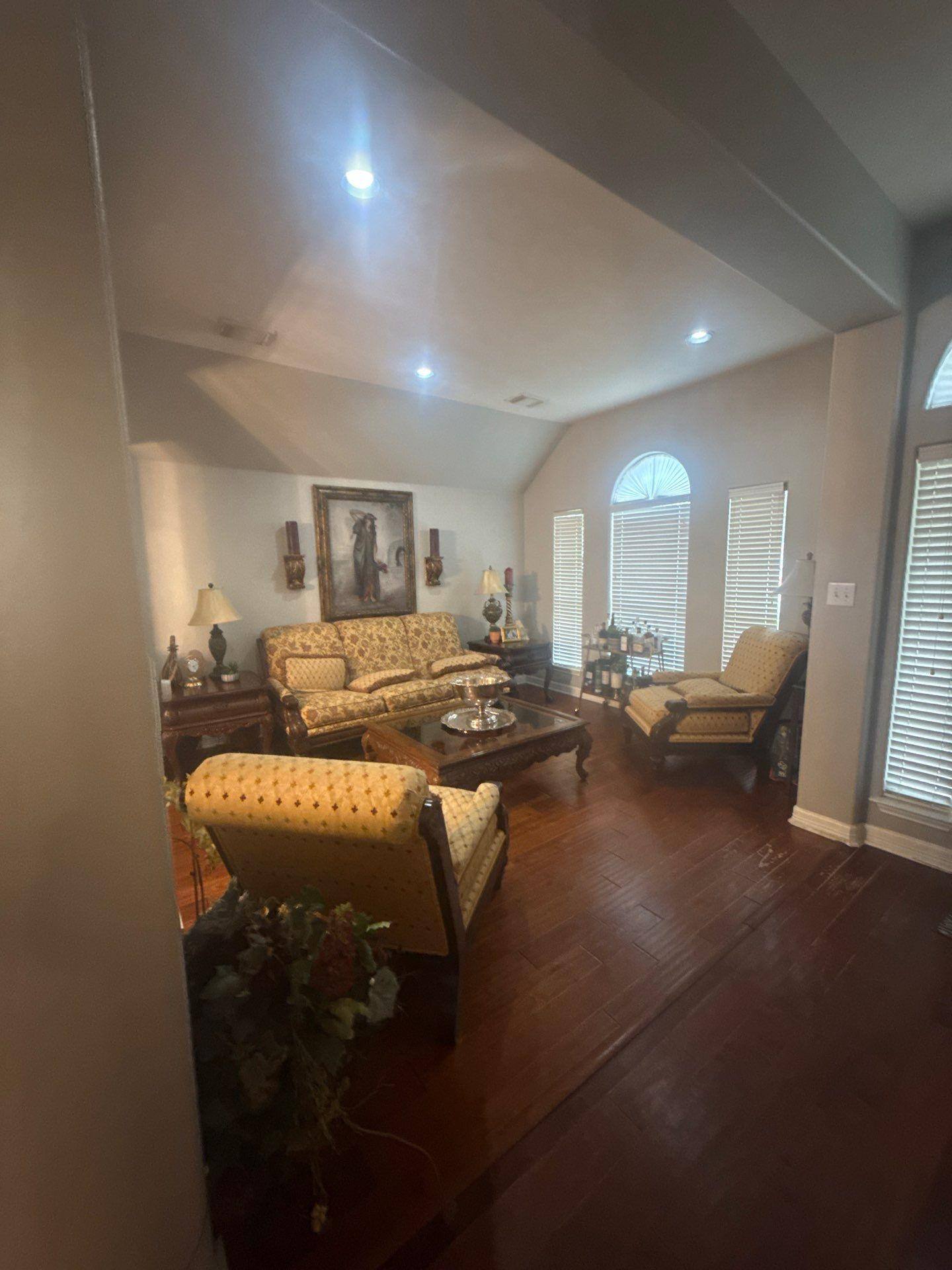 Living room with vaulted ceiling in a home on Laurel Bay Loop in Round Rock, TX prepared for ceiling painting by Hill Country Painting