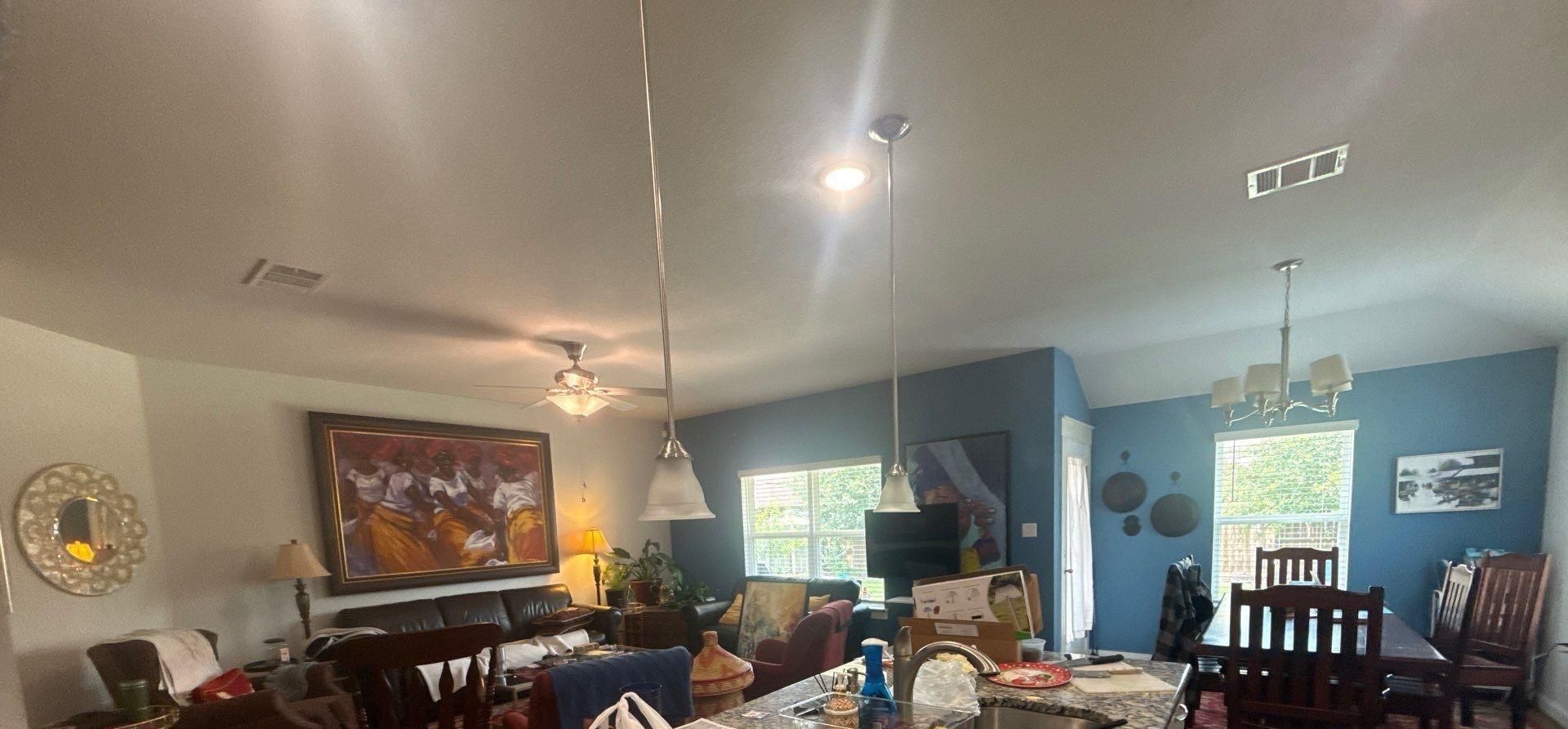 Living room and dining room in a home on Emerald Springs Ln in Manor, TX prepared for interior painting by Hill Country Painting