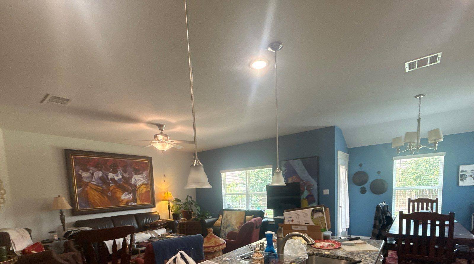Living room and dining room in a home on Emerald Springs Ln in Manor, TX prepared for interior painting by Hill Country Painting