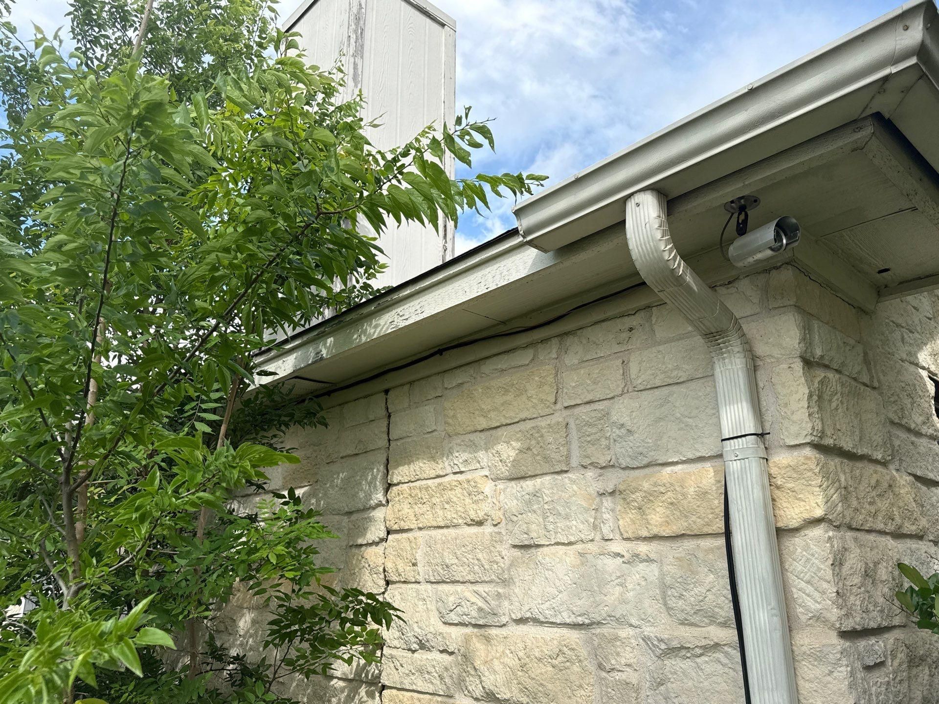 Gutter and downspout on a home on Cora Marie Dr in Pflugerville, TX prepared for exterior painting by Hill Country Painting