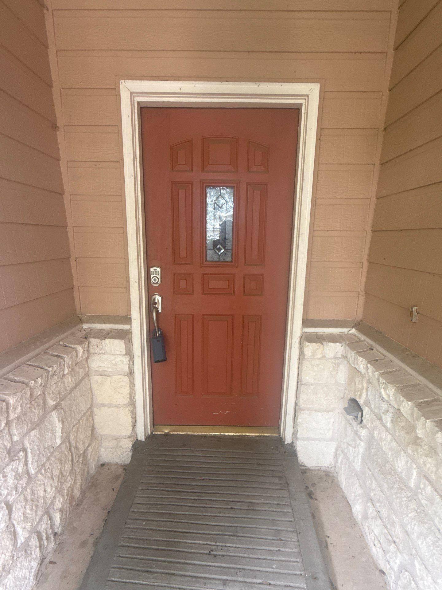 Entry door on a home on Cora Marie Dr in Pflugerville, TX prepared for painting by Hill Country Painting