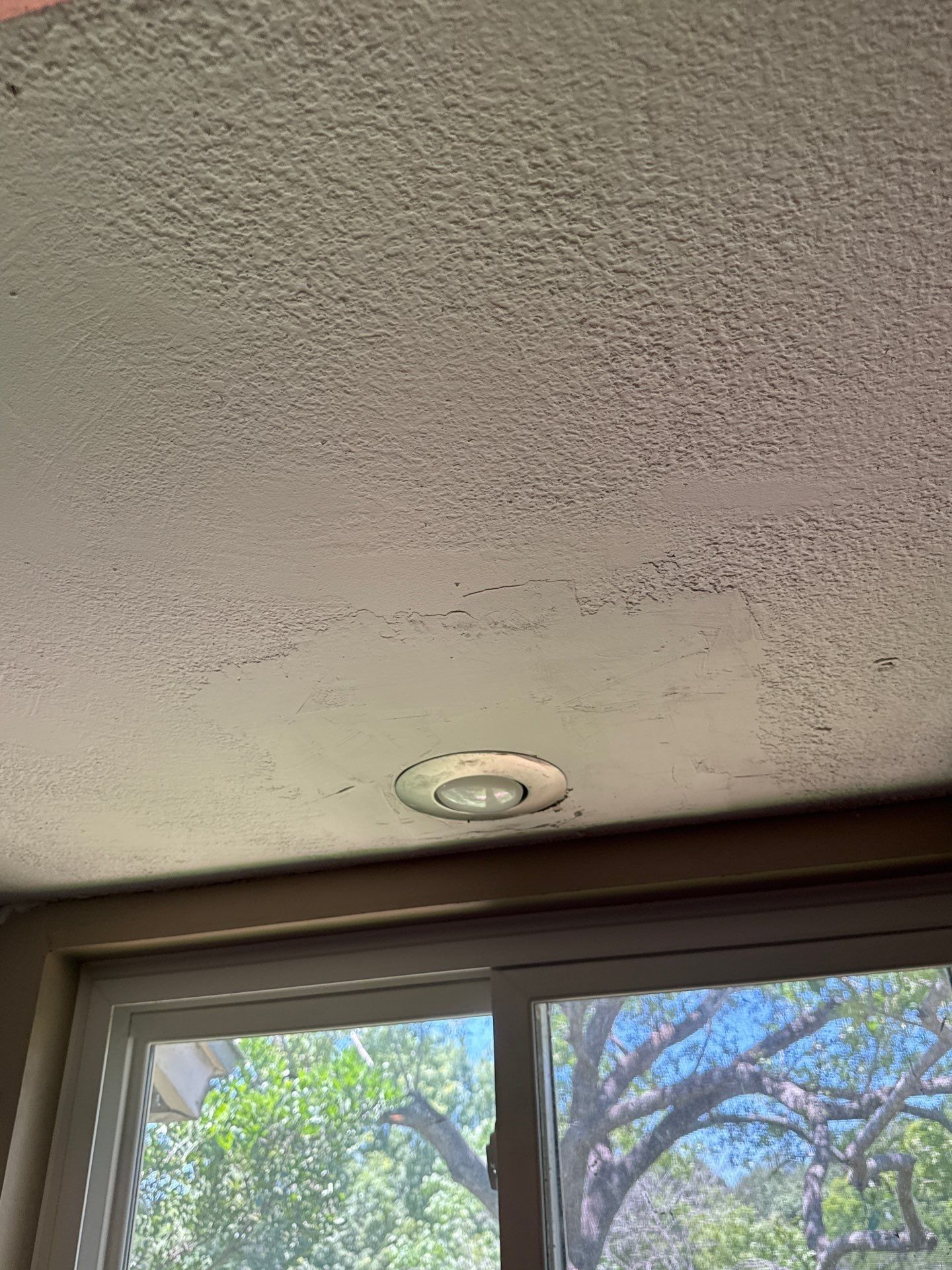 Ceiling texture crack near a window in a home on Granada Hills Dr in Austin, TX before re-texture and painting by Hill Country Painting