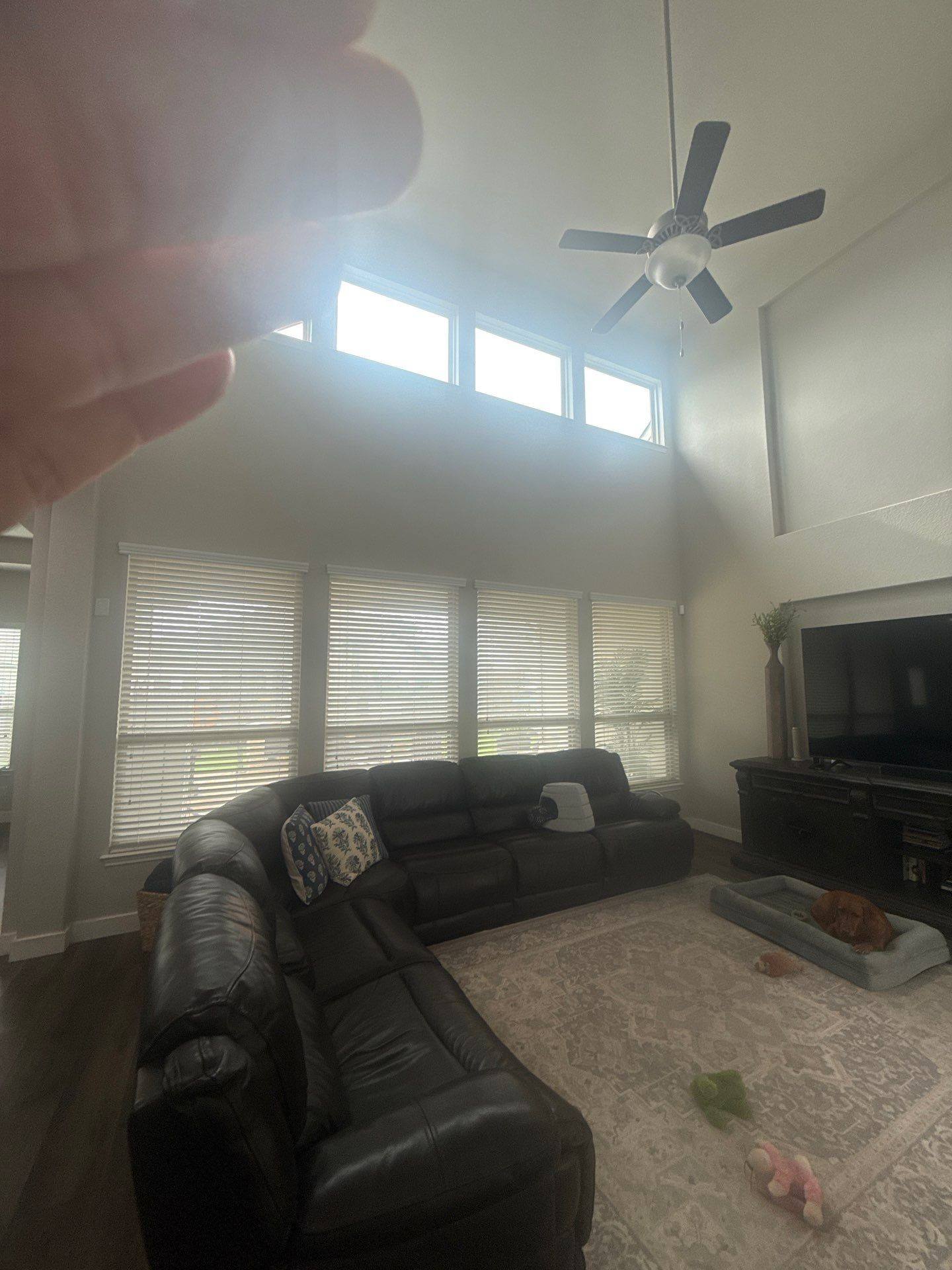 Living room with vaulted ceiling in a home on Kite Wing Ter in Pflugerville, TX prepared for painting by Hill Country Painting