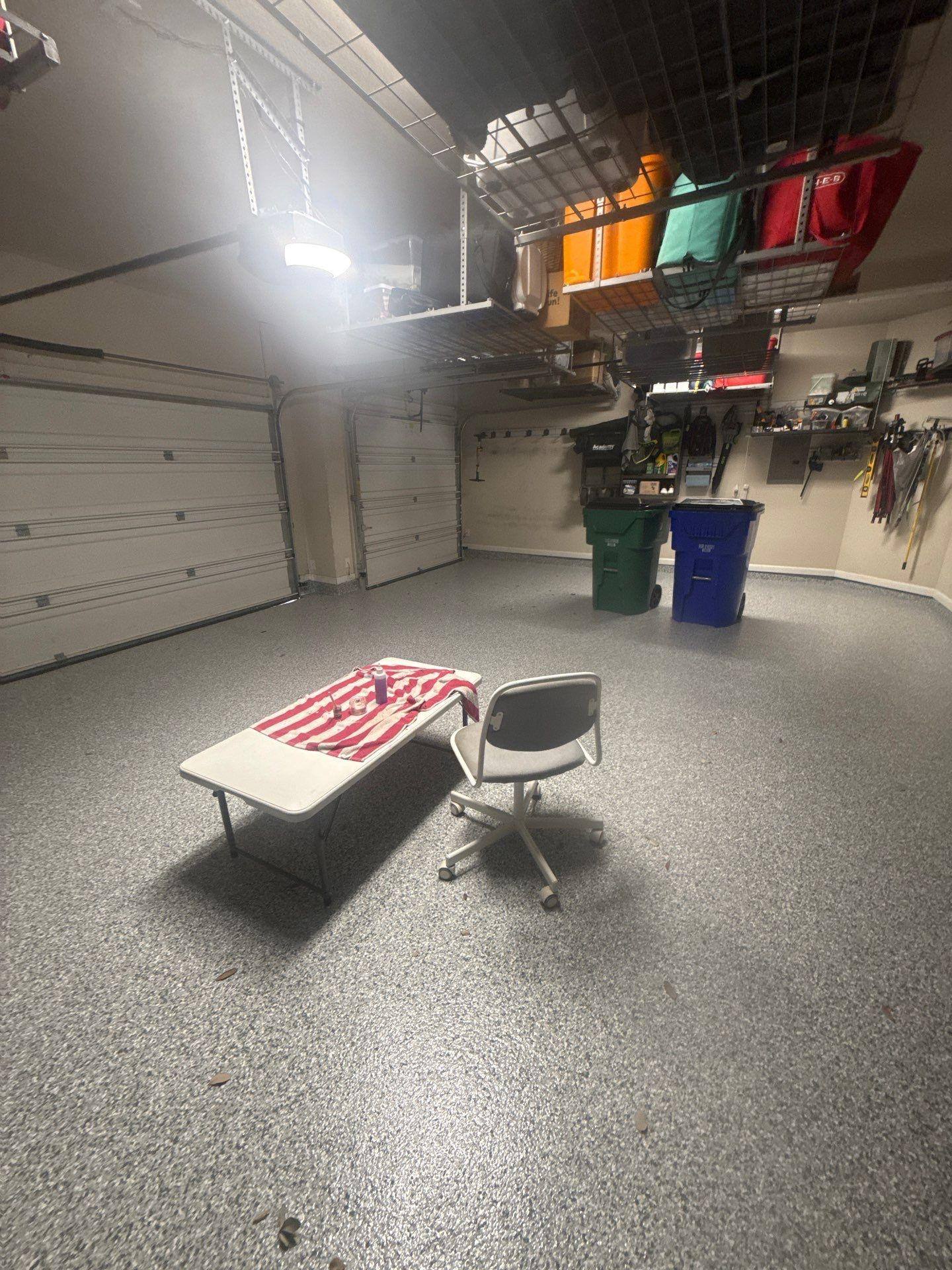 Garage with epoxy floor and storage in a home on Mossy Grove Ct in Cedar Park, TX prepared for painting by Hill Country Painting