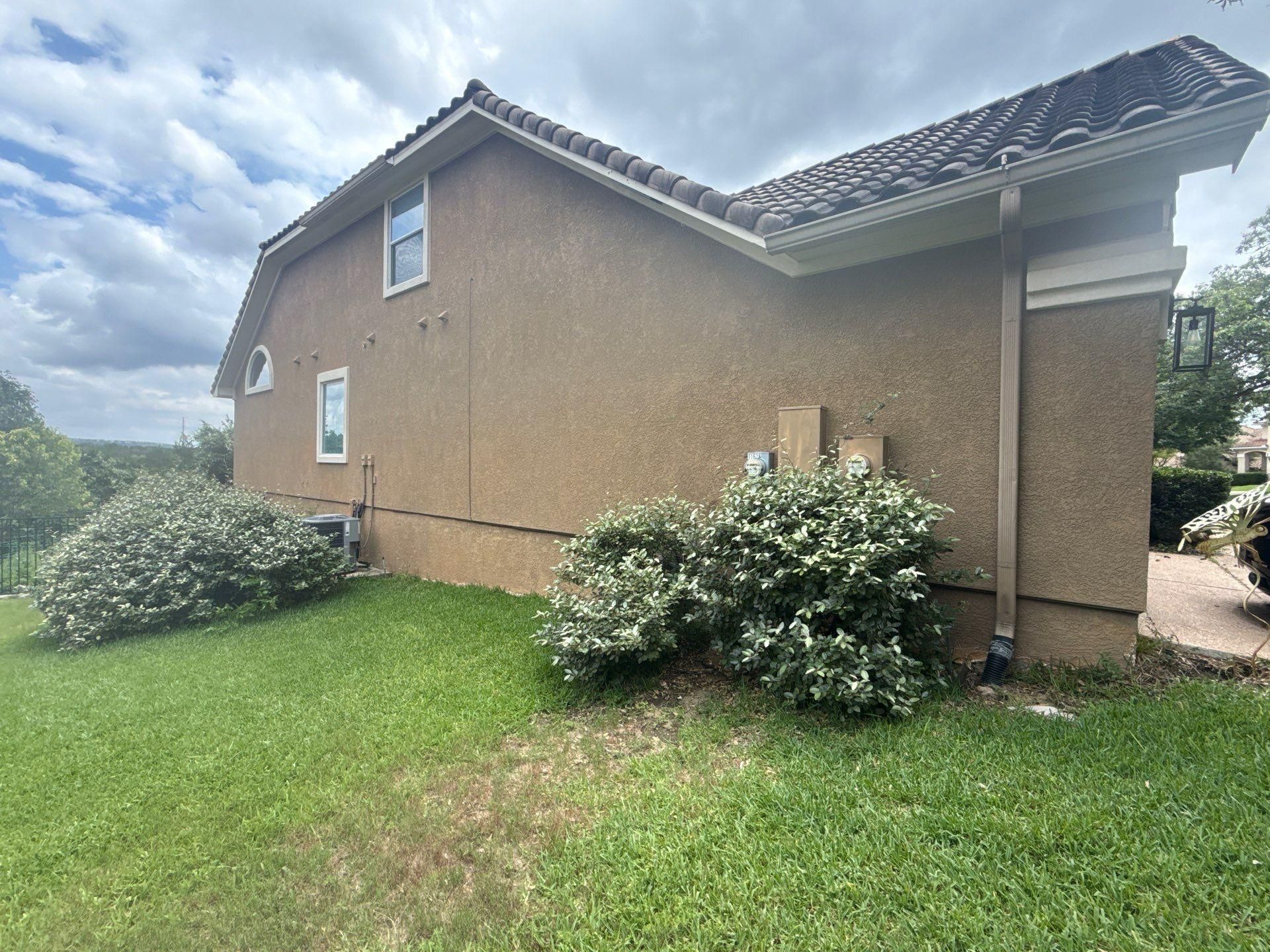 Left side of a home on Woodland Hills Trail in Austin, TX prepared for painting by Hill Country Painting