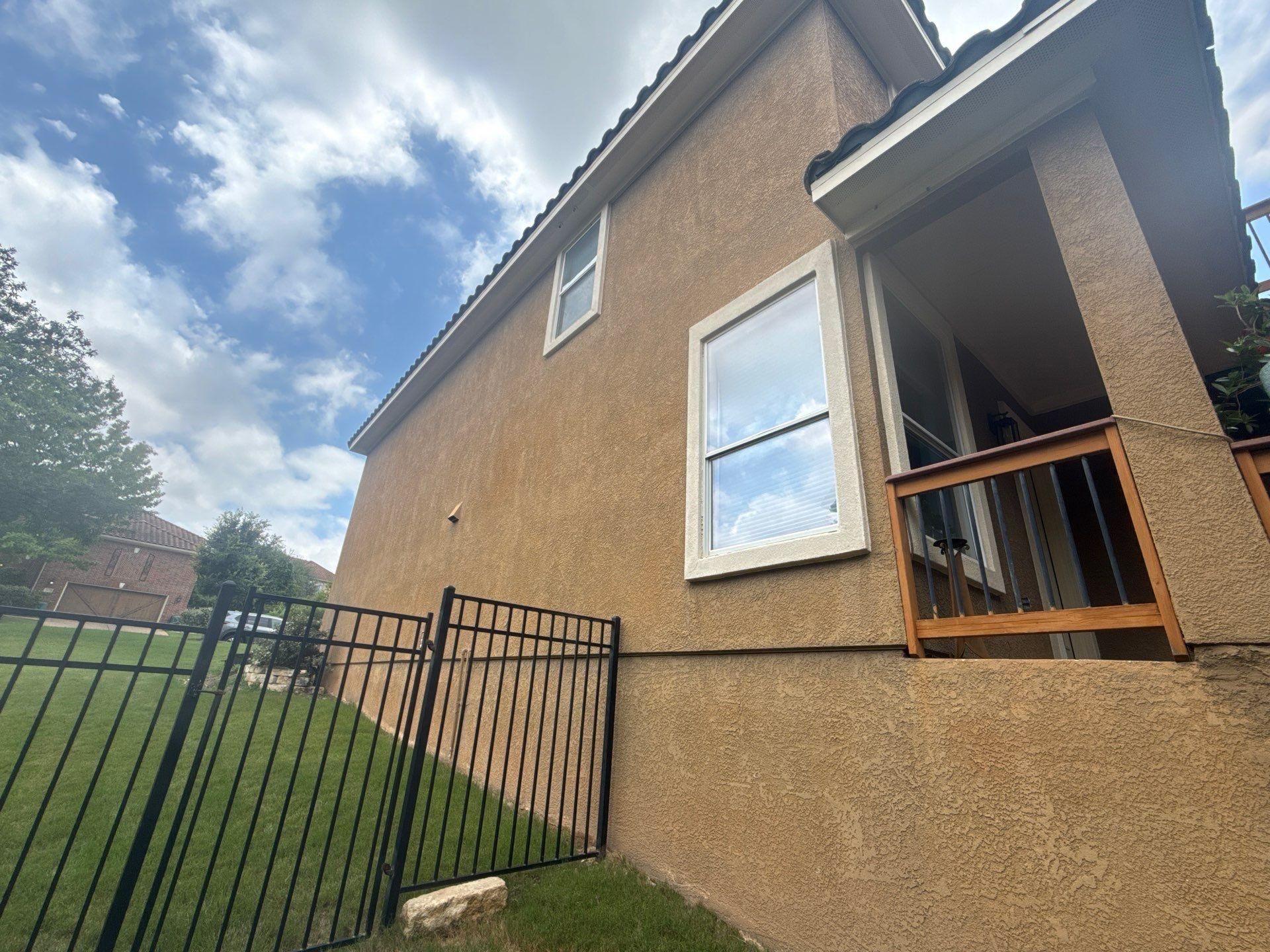 Side of a home on Woodland Hills Trail in Austin, TX with balcony prepared for painting by Hill Country Painting