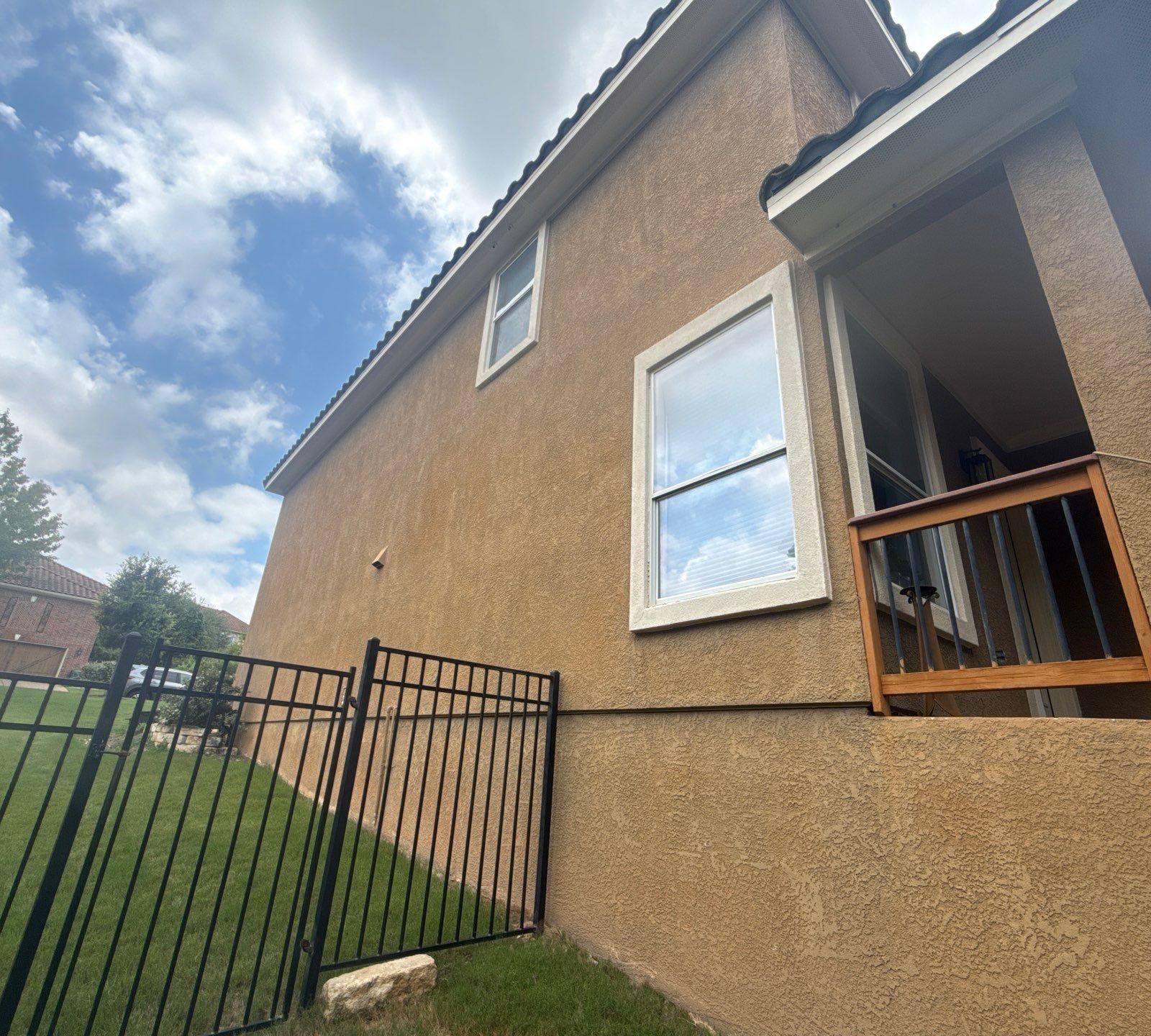 Side of a home on Woodland Hills Trail in Austin, TX with balcony prepared for painting by Hill Country Painting