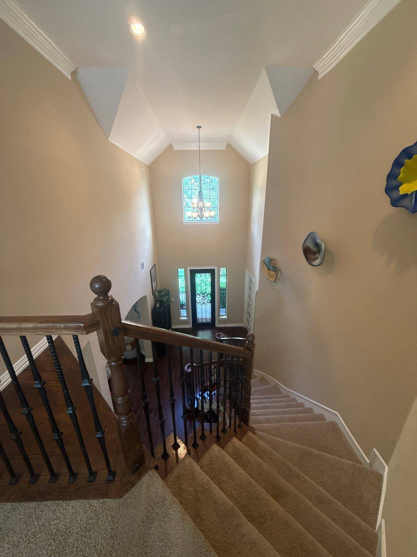 Entryway and stairwell of a home on Straw Flower Dr in Austin, TX prepared for painting by Hill Country Painting