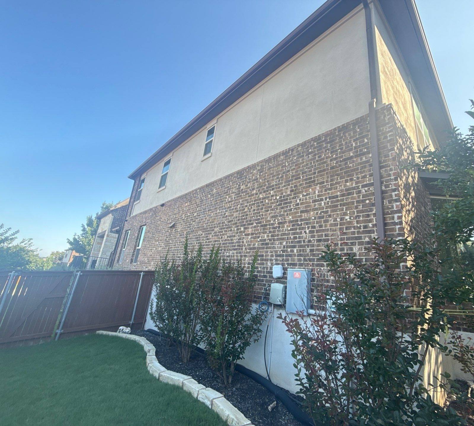 Side elevation with brick and stucco siding at a home on Borho Ranch St in Leander, TX prepared for a painting estimate by Hill Country Painting