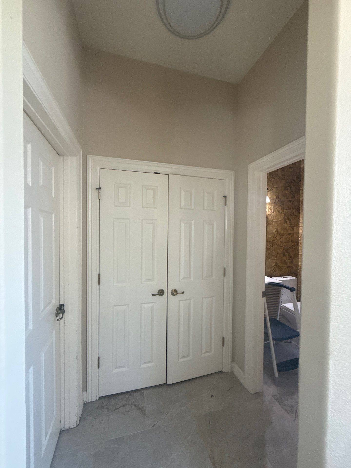 Upstairs hallway and closet doors in a home on Spicewood Pkwy in Austin, TX prepared for an interior painting estimate by Hill Country Painting