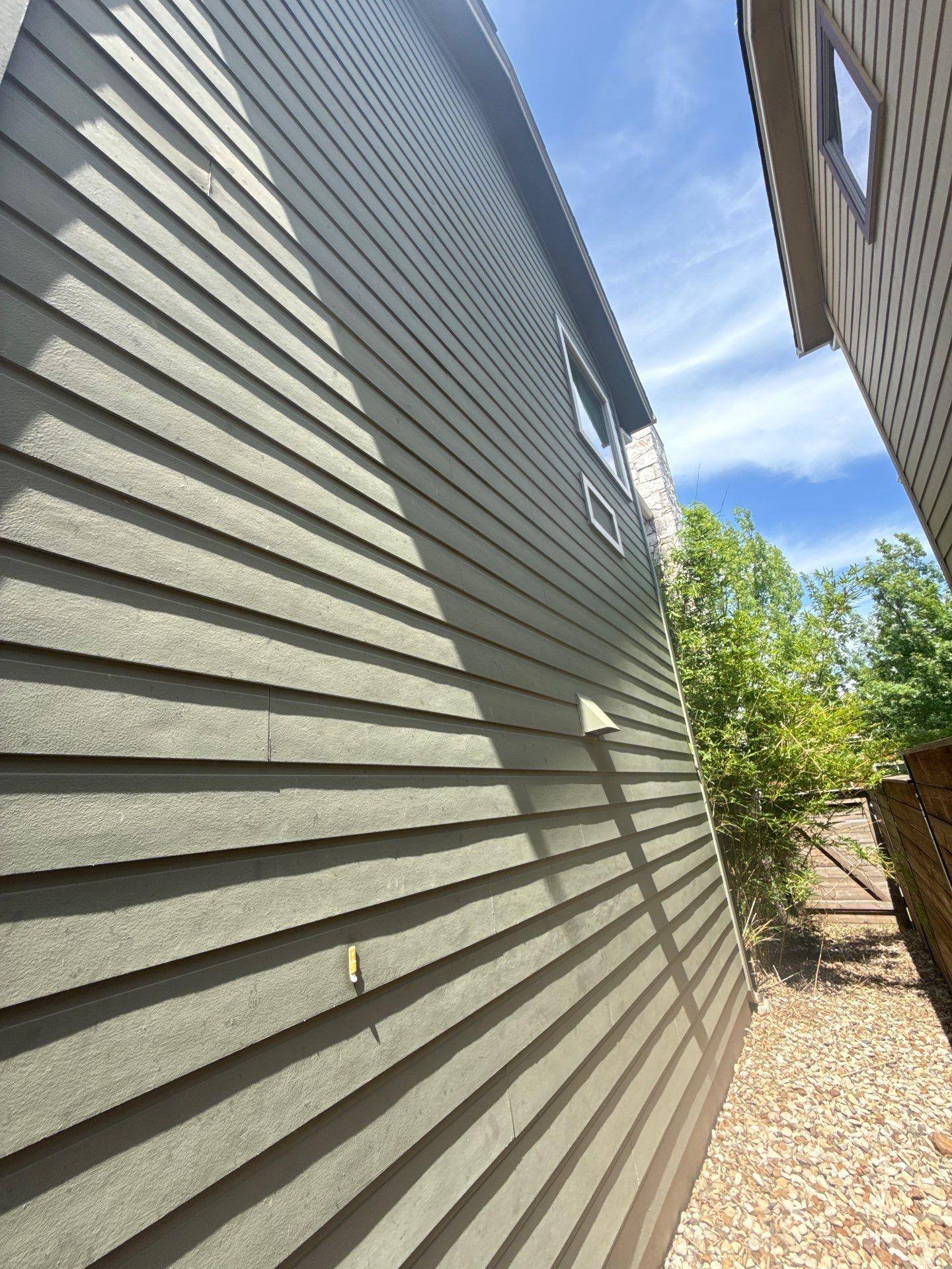 Side elevation siding detail of a home on Gochman St in Austin, TX prepared for an exterior painting estimate by Hill Country Painting