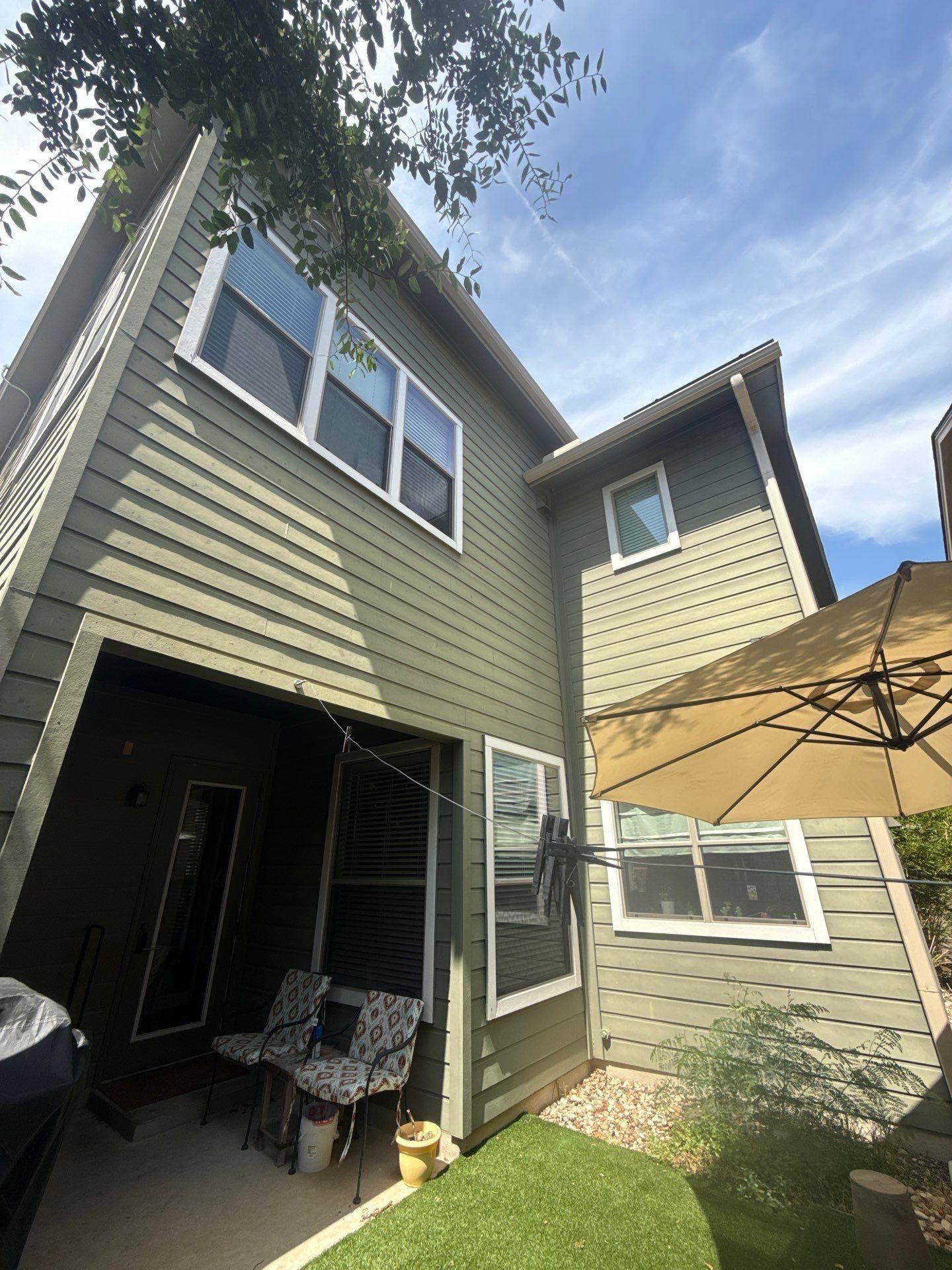 Back exterior of a home on Gochman St in Austin, TX prepared for an exterior painting estimate by Hill Country Painting