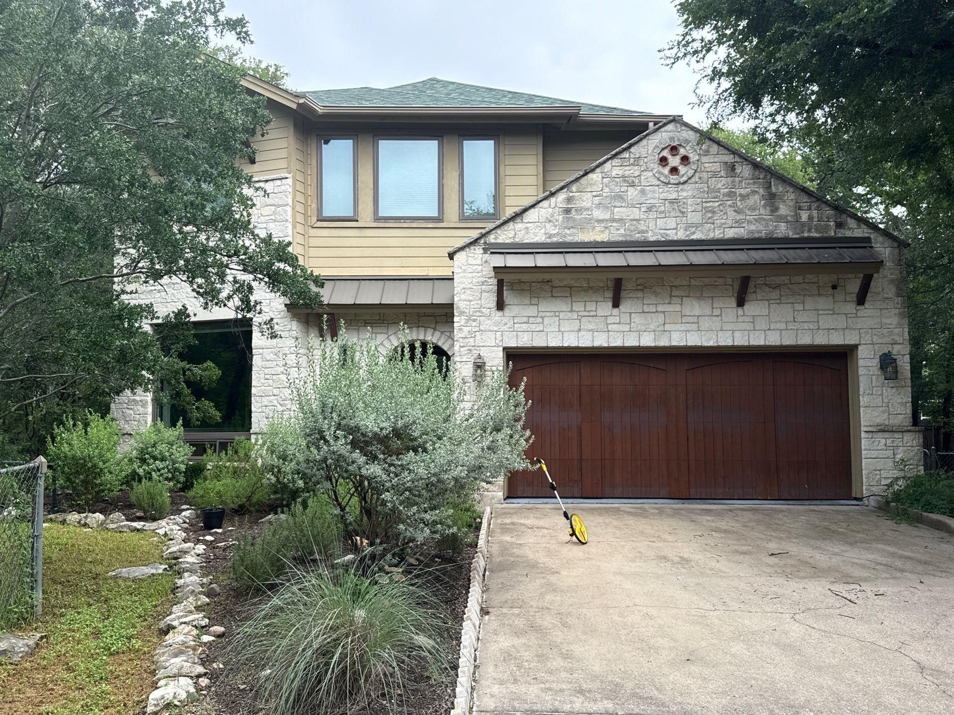 Front elevation with garage of a home on Gregory Pl in Austin, TX prepared for an exterior painting estimate by Hill Country Painting