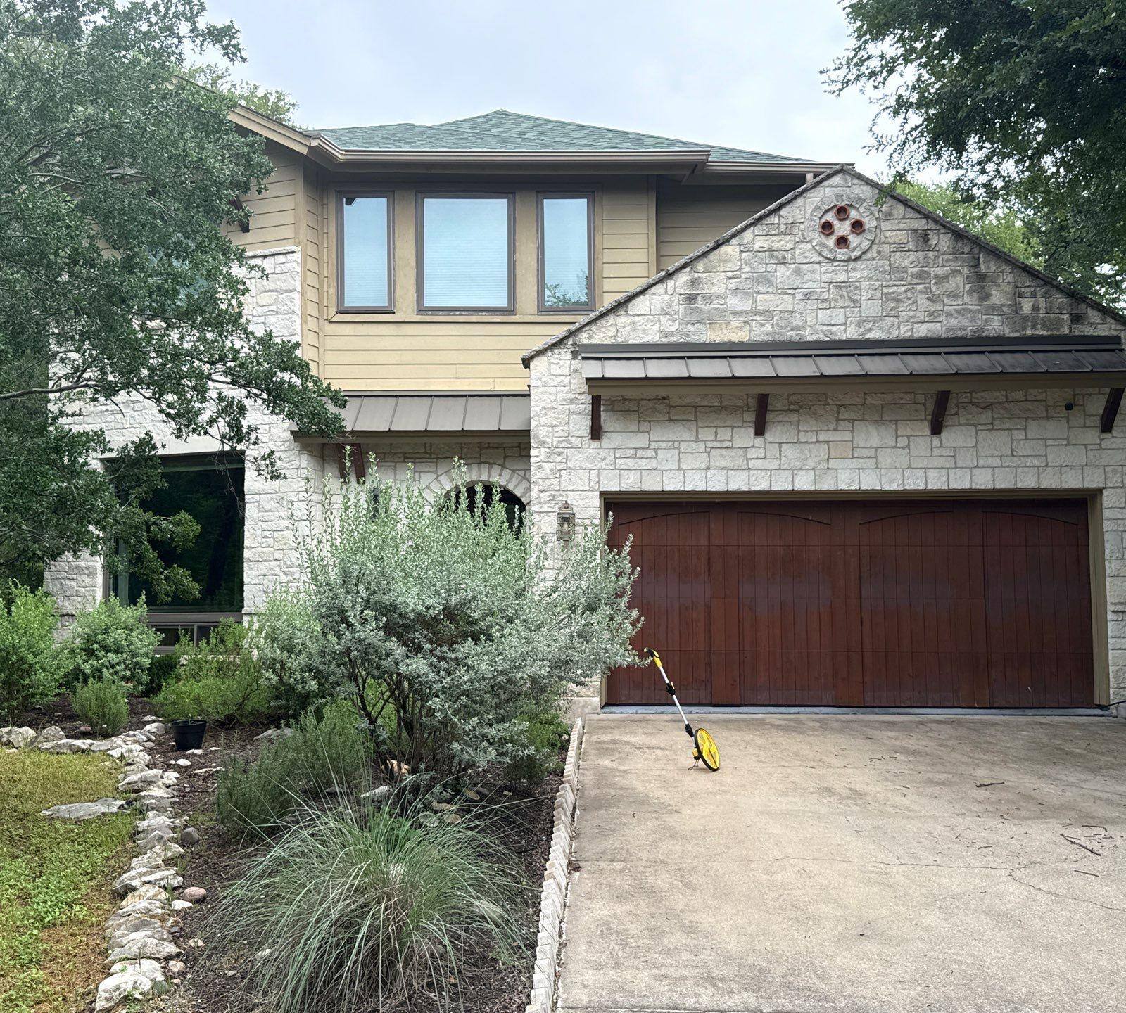 Front elevation with garage of a home on Gregory Pl in Austin, TX prepared for an exterior painting estimate by Hill Country Painting