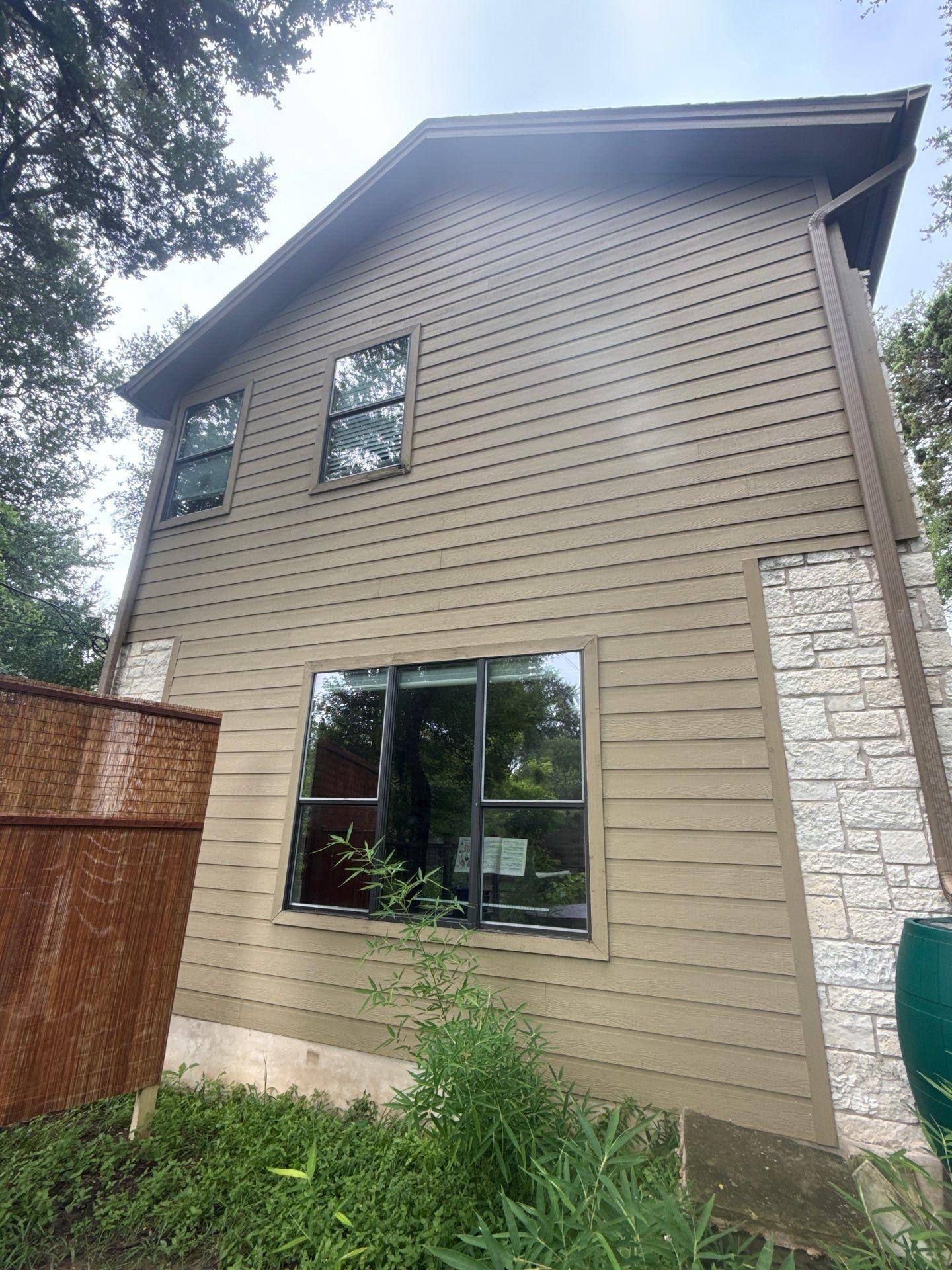 Side elevation of a home on Gregory Pl in Austin, TX prepared for an exterior painting estimate by Hill Country Painting