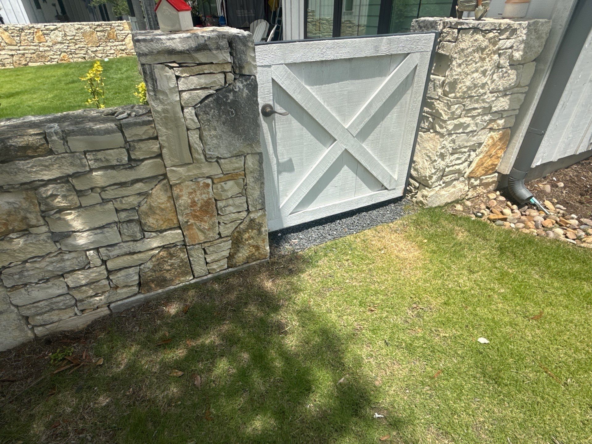 Stone wall and gate detail on a property on Flying J Blvd in Spicewood, TX ahead of an exterior painting estimate by Hill Country Painting