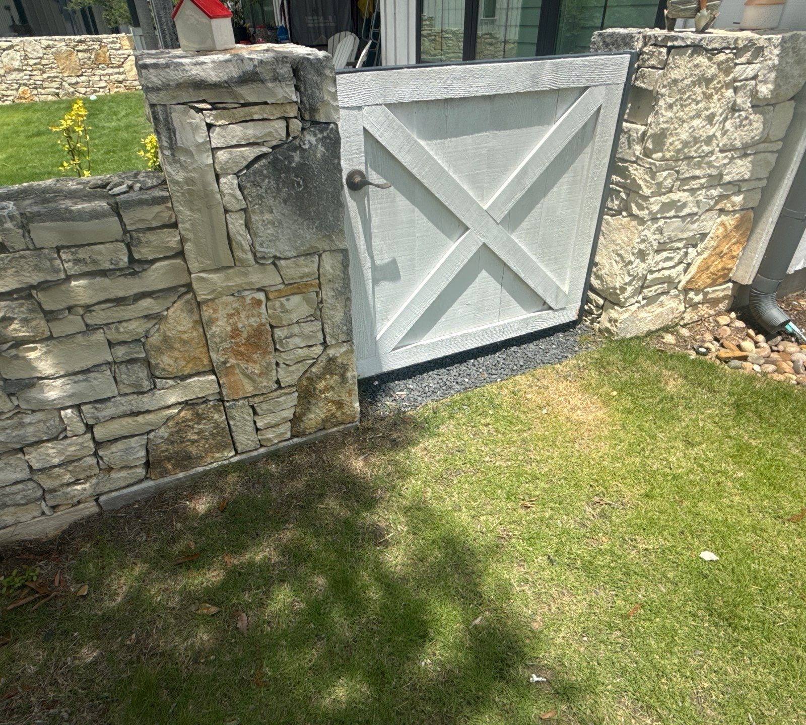 Stone wall and gate detail on a property on Flying J Blvd in Spicewood, TX ahead of an exterior painting estimate by Hill Country Painting