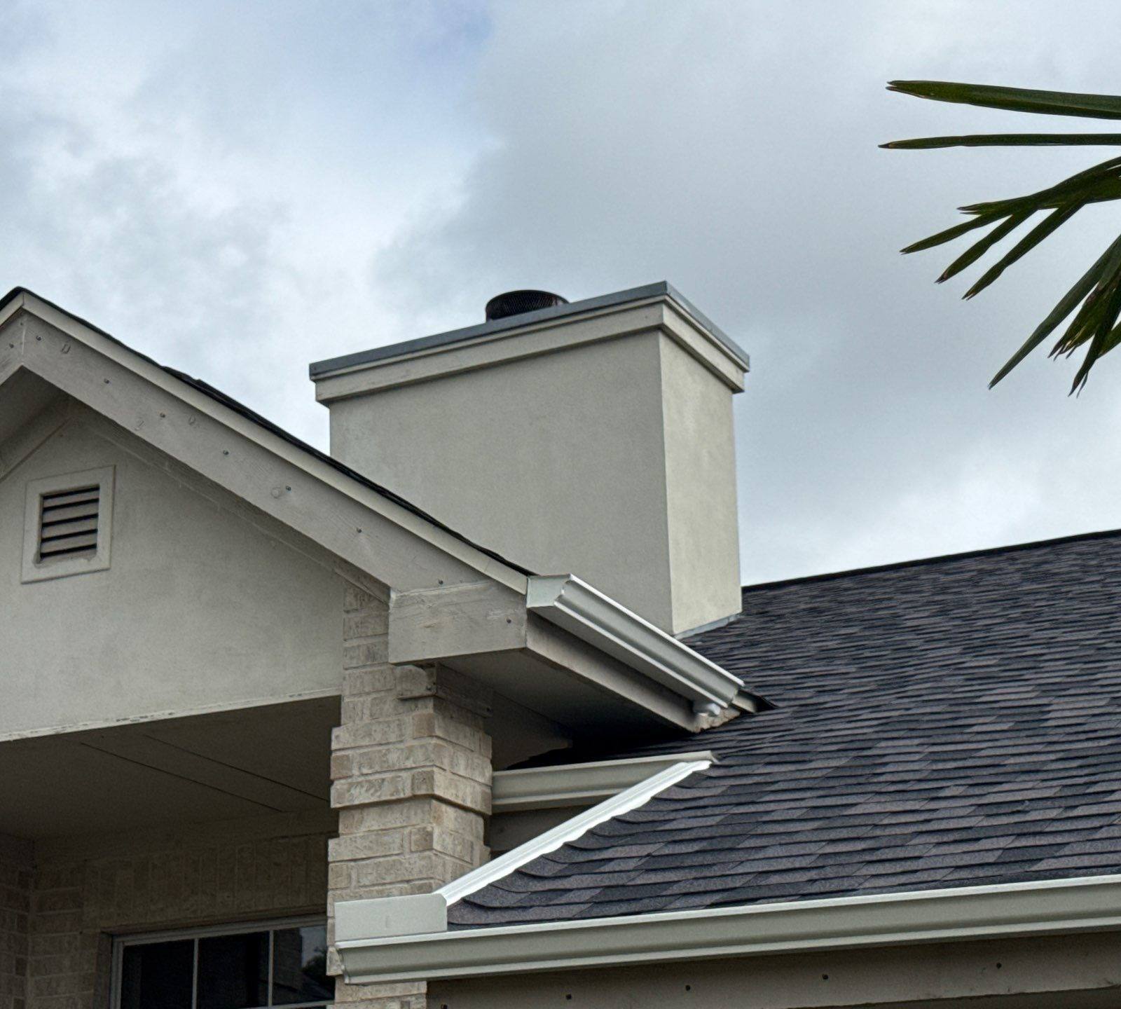 Chimney and roofline of a home on Boggy Ford Rd in Lago Vista, TX ahead of exterior painting by Hill Country Painting