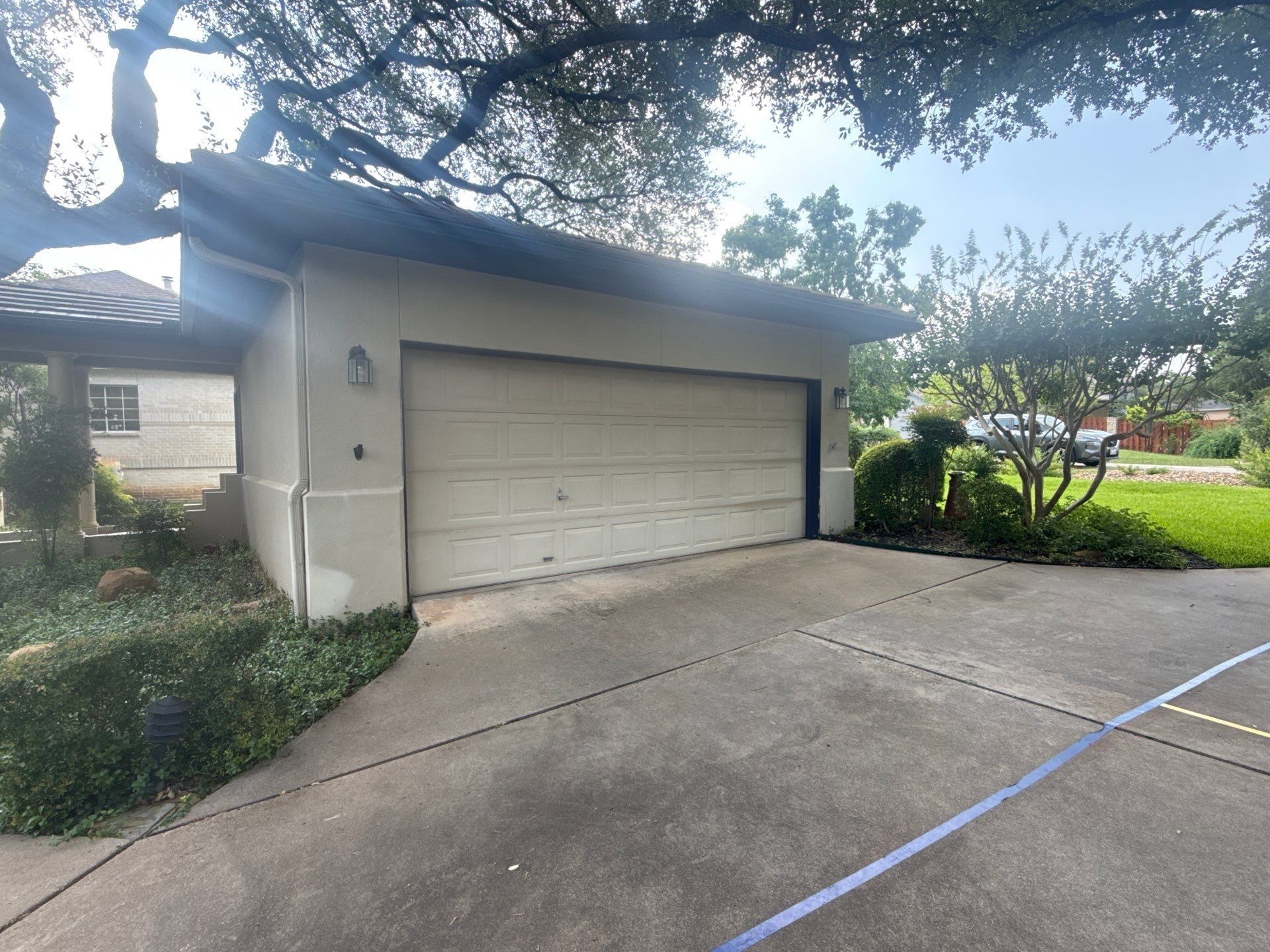 Garage door of a home on Tellus St in Lakeway, TX ahead of exterior painting by Hill Country Painting