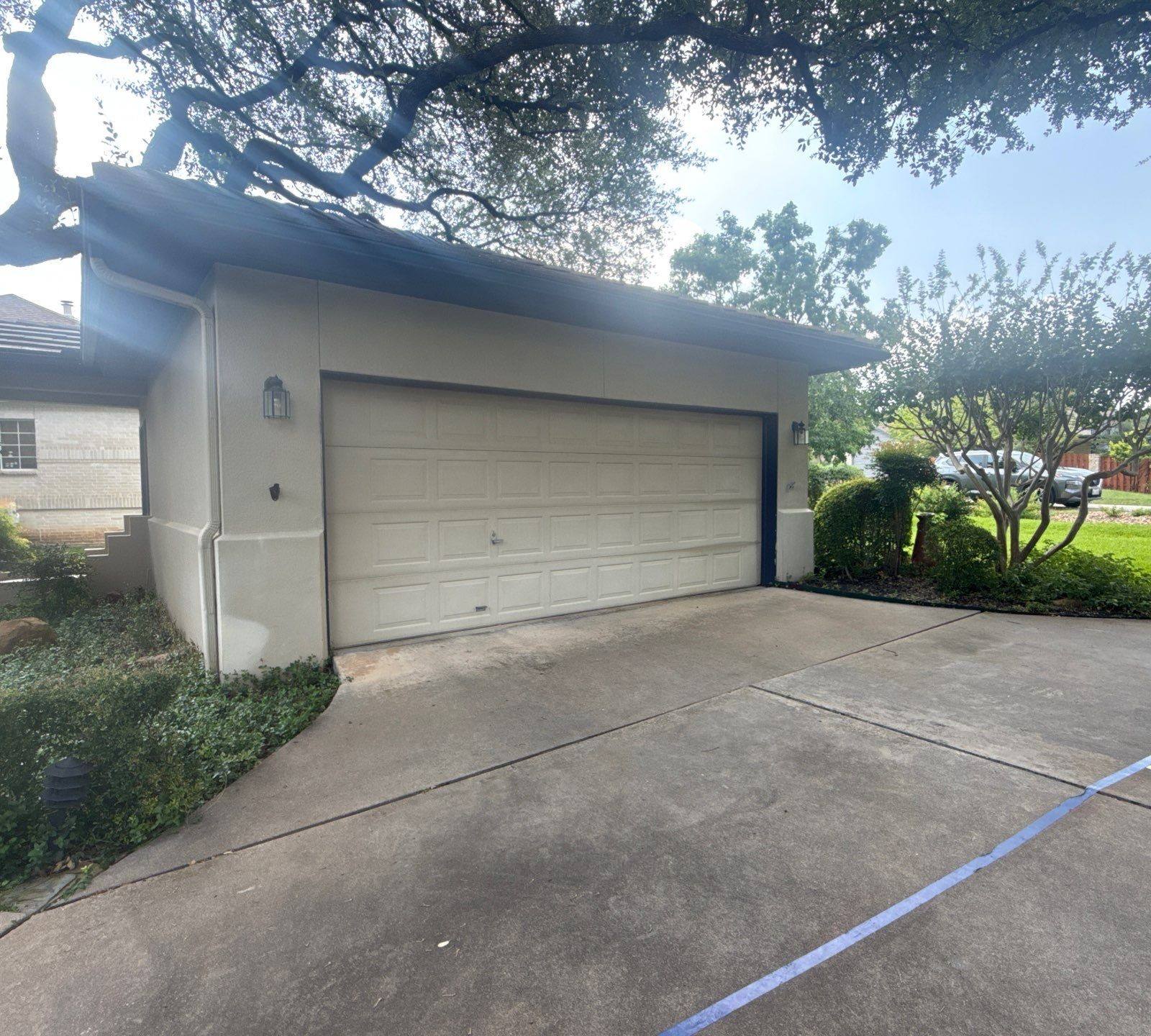 Garage door of a home on Tellus St in Lakeway, TX ahead of exterior painting by Hill Country Painting