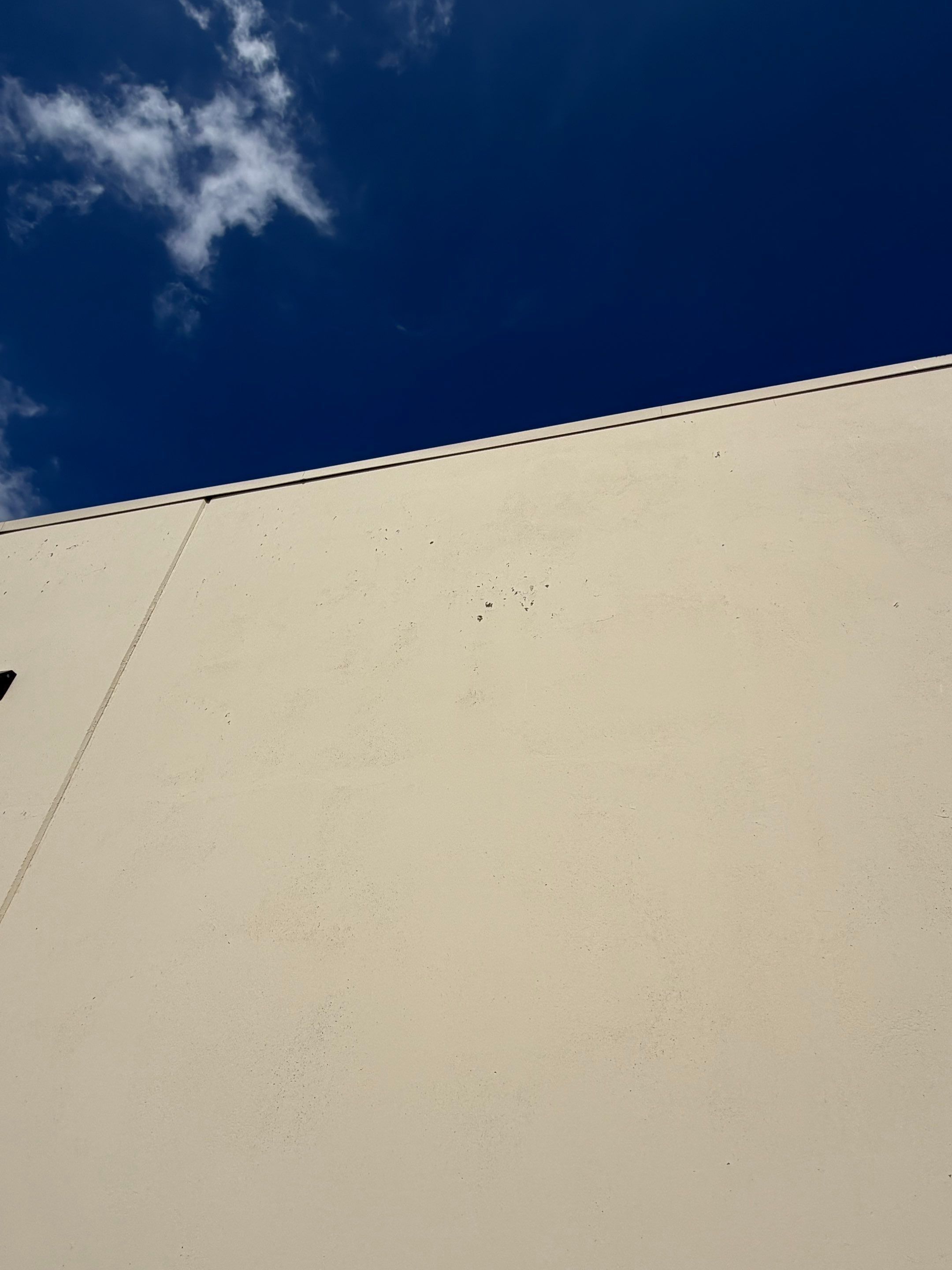 Exterior wall surface of a commercial building on Highway 79 in Hutto, TX ahead of exterior painting by Hill Country Painting
