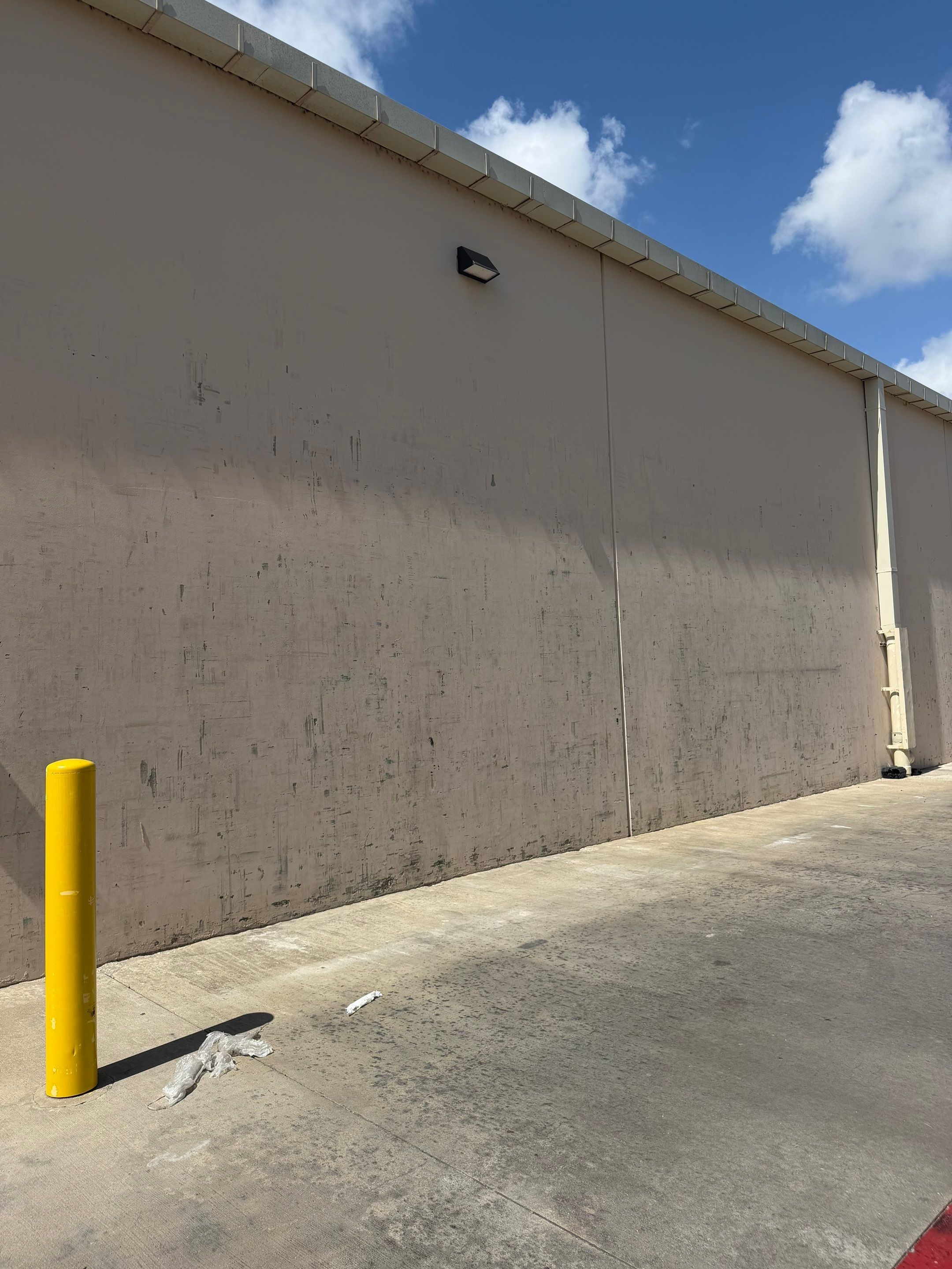 Side wall of a commercial building on Highway 79 in Hutto, TX showing weathering ahead of exterior painting by Hill Country Painting