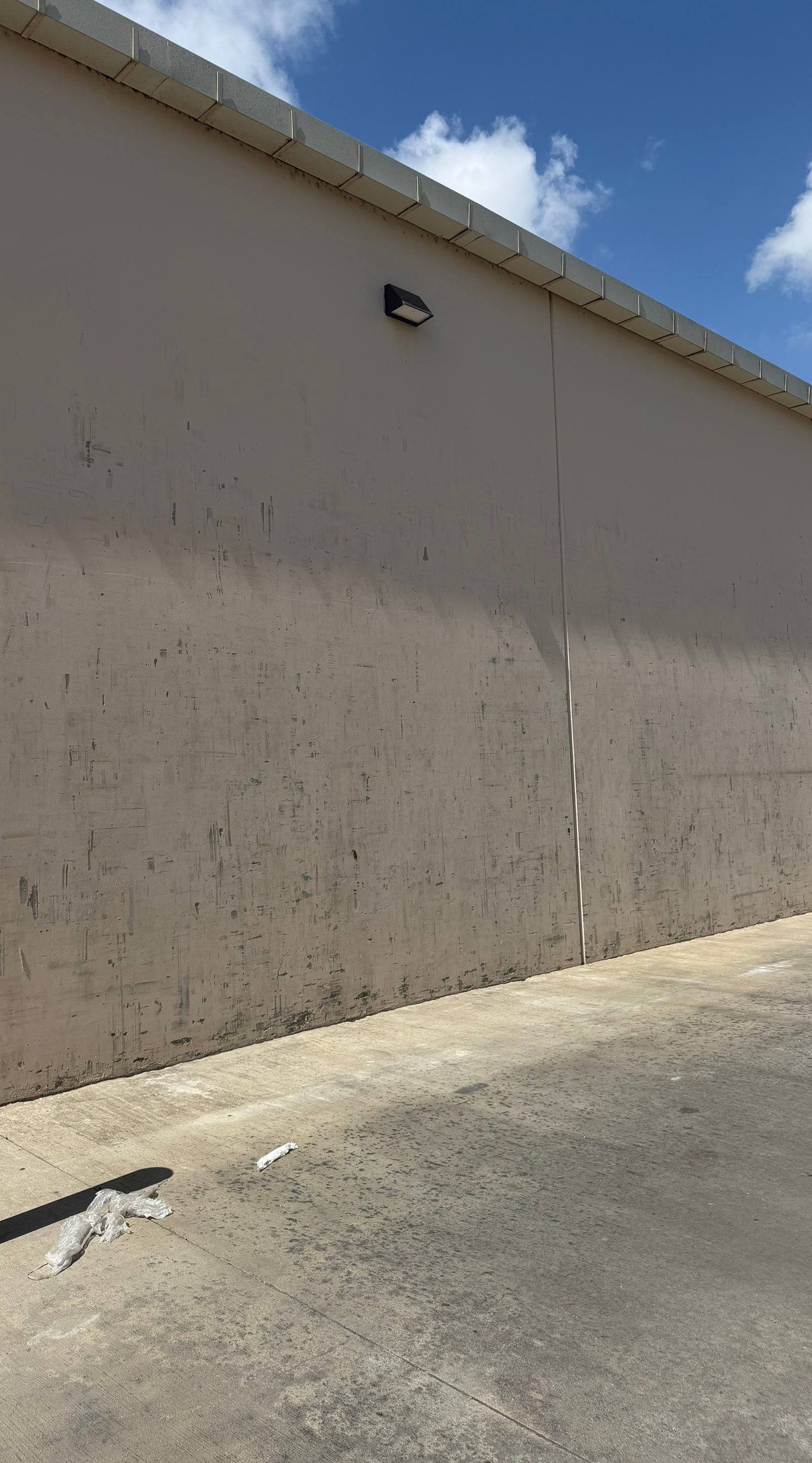 Side wall of a commercial building on Highway 79 in Hutto, TX showing weathering ahead of exterior painting by Hill Country Painting