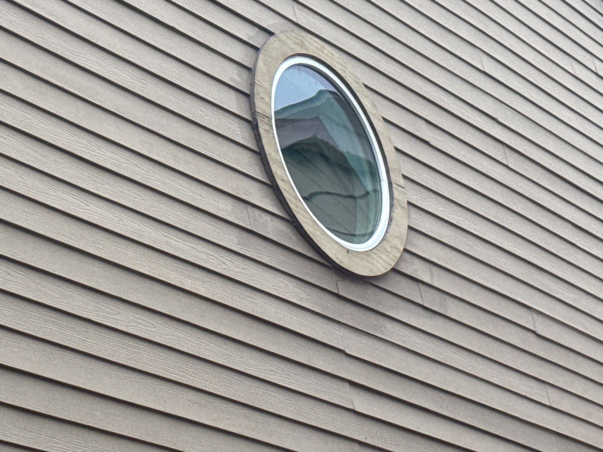 Round window detail on a home on Weatherwood Cove in Austin, TX ahead of exterior painting by Hill Country Painting