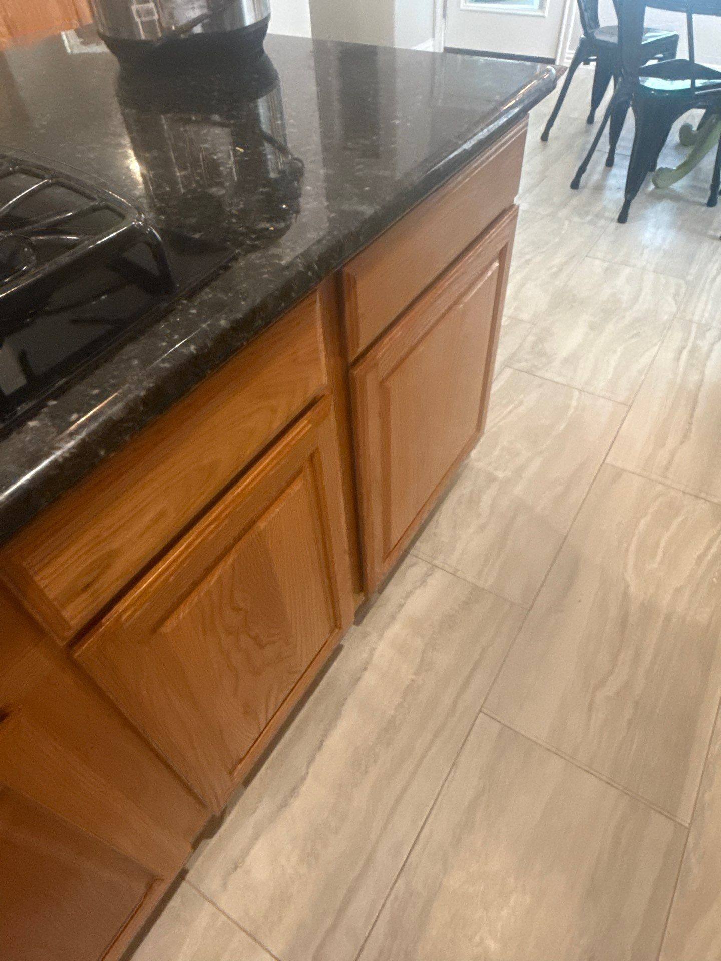 Kitchen island cabinets in a home on Spindletop Ter in Round Rock, TX ahead of cabinet refinishing by Hill Country Painting