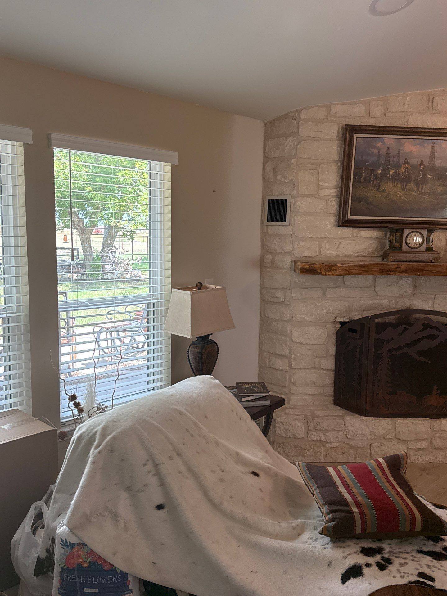 Living room with stone fireplace at a property on Co Rd 120 in Georgetown, TX ahead of interior painting by Hill Country Painting