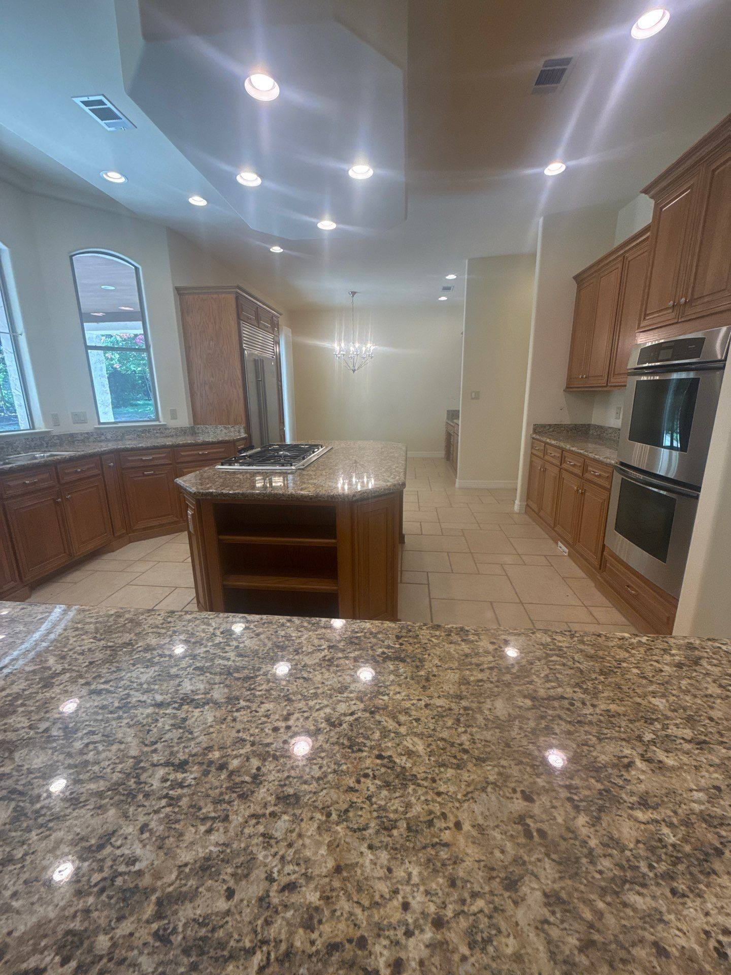 Kitchen with granite island at a property on Lakeway Hills Cv in Lakeway, TX ahead of whole-home interior painting by Hill Country Painting
