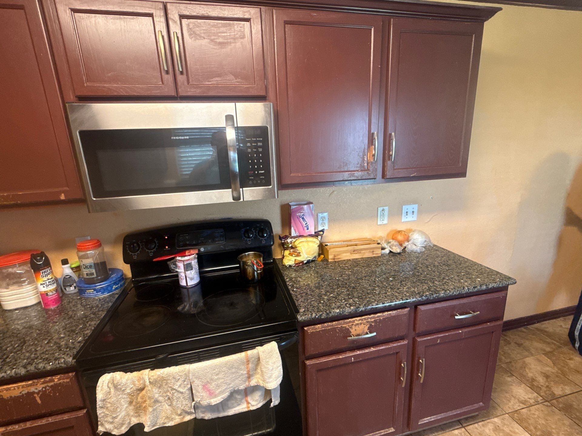Kitchen cabinets at a property on Pine Needle St in Manor, TX ahead of cabinet refinishing by Hill Country Painting