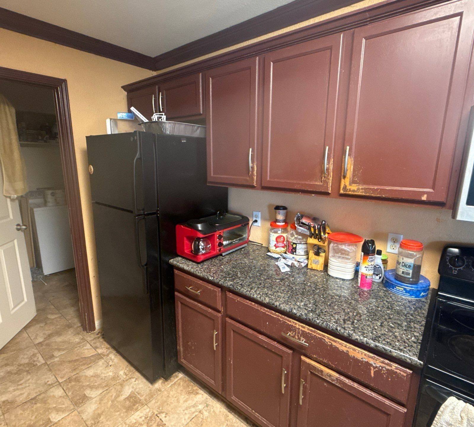 Kitchen cabinets at a property on Pine Needle St in Manor, TX ahead of cabinet refinishing by Hill Country Painting