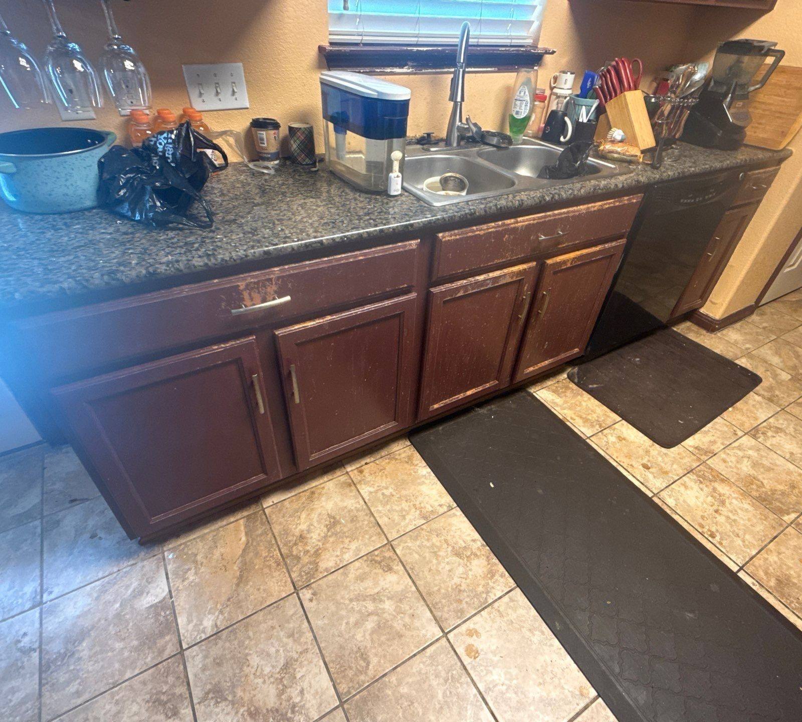 Kitchen cabinets at a property on Pine Needle St in Manor, TX ahead of cabinet refinishing by Hill Country Painting