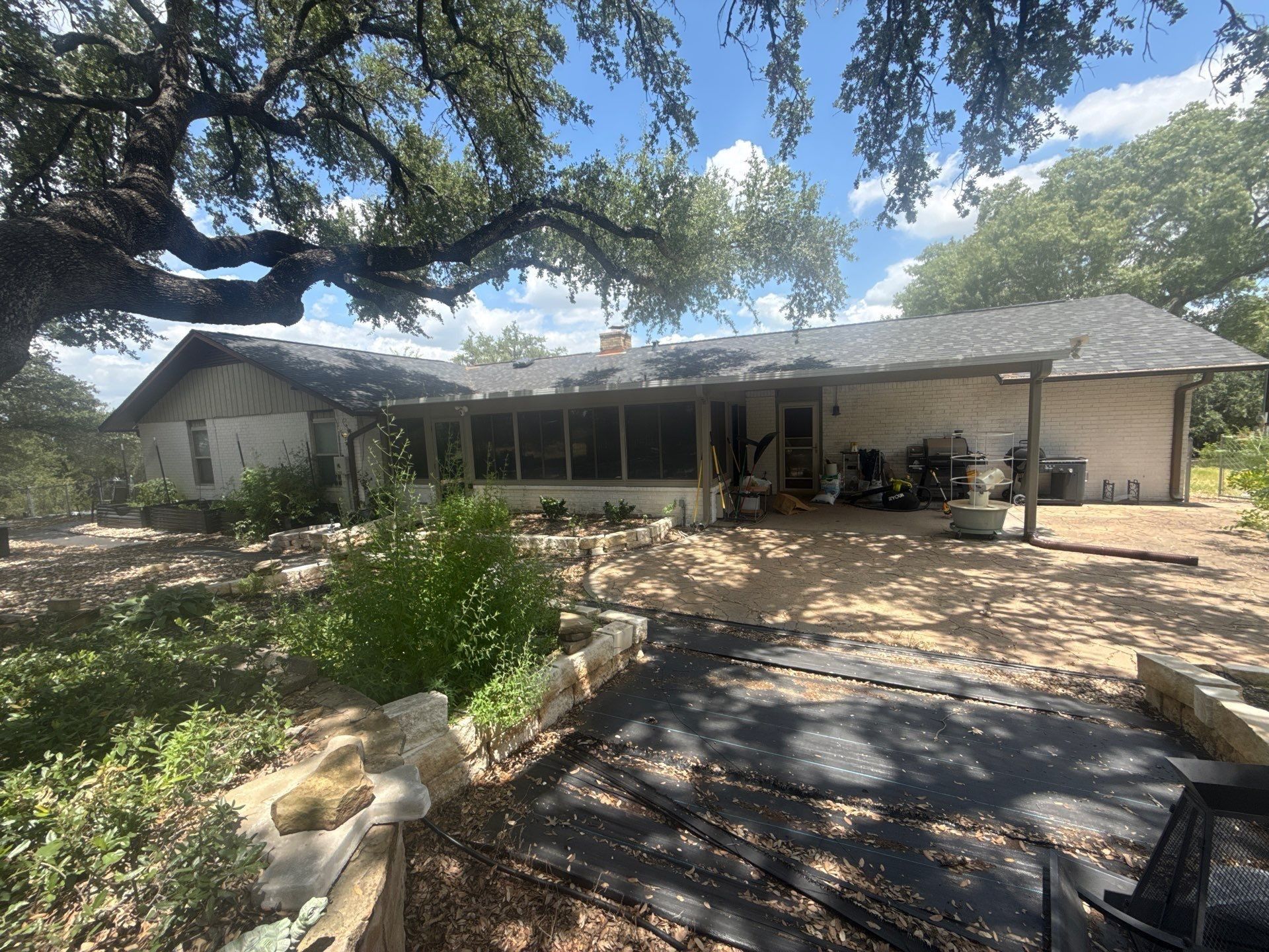 Rear exterior of the home ahead of painting, with covered patio