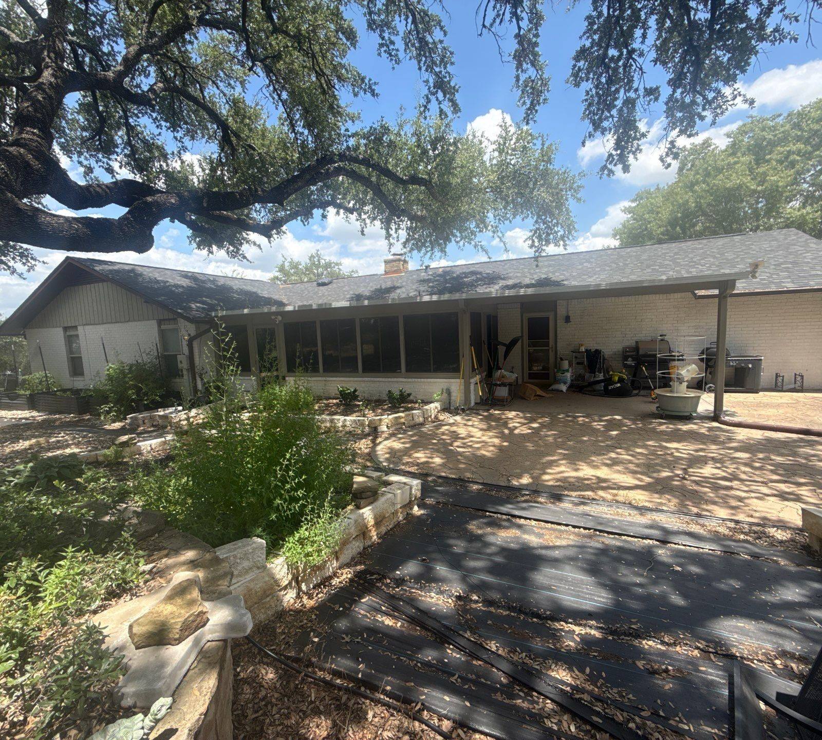 Rear exterior of the home ahead of painting, with covered patio