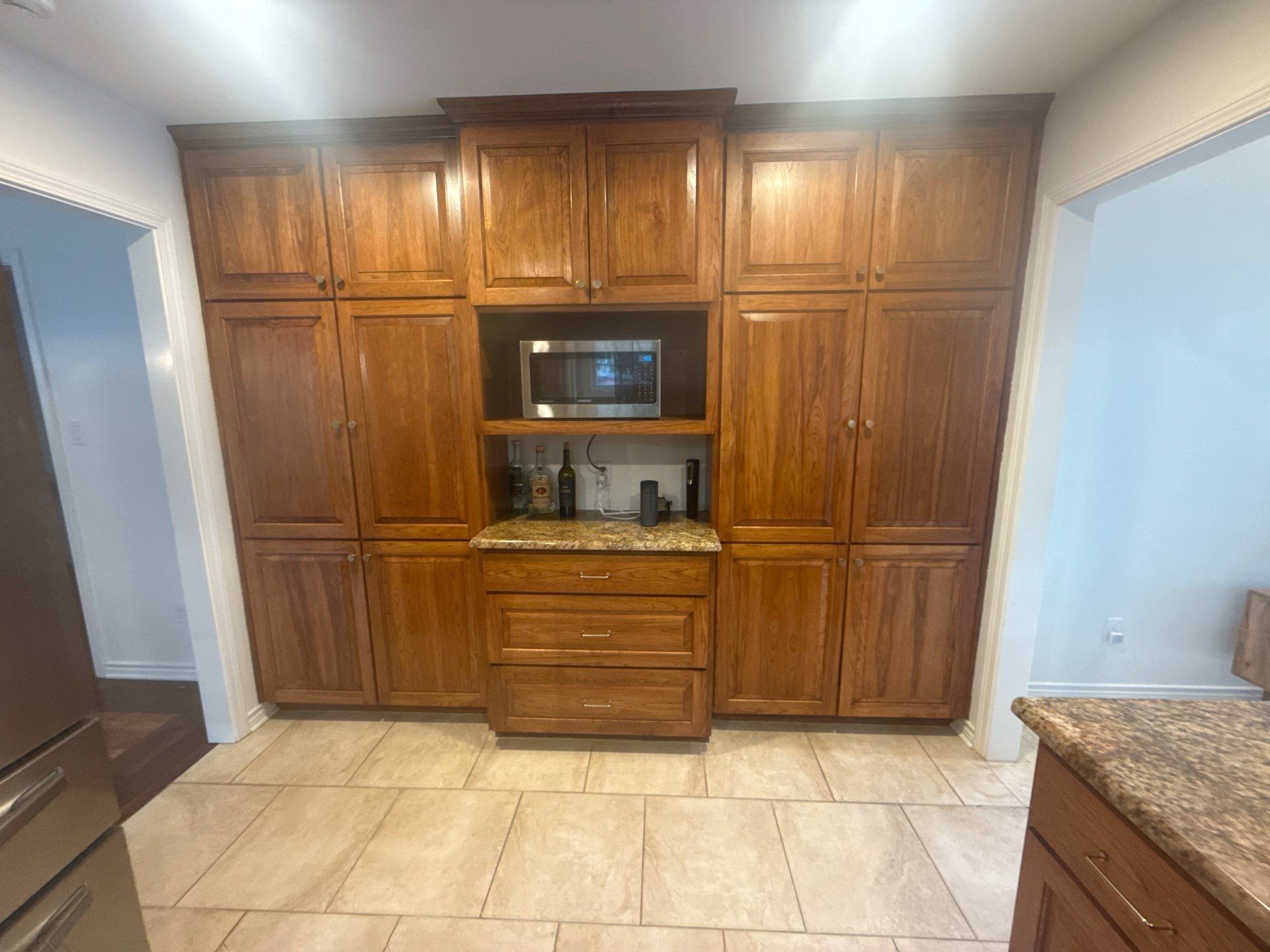 Tall kitchen cabinet wall with built-in microwave nook ahead of painting