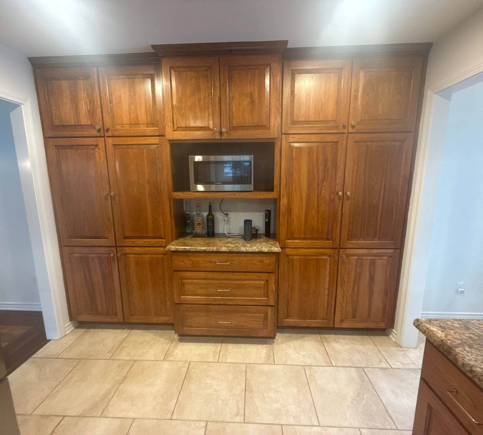 Tall kitchen cabinet wall with built-in microwave nook ahead of painting