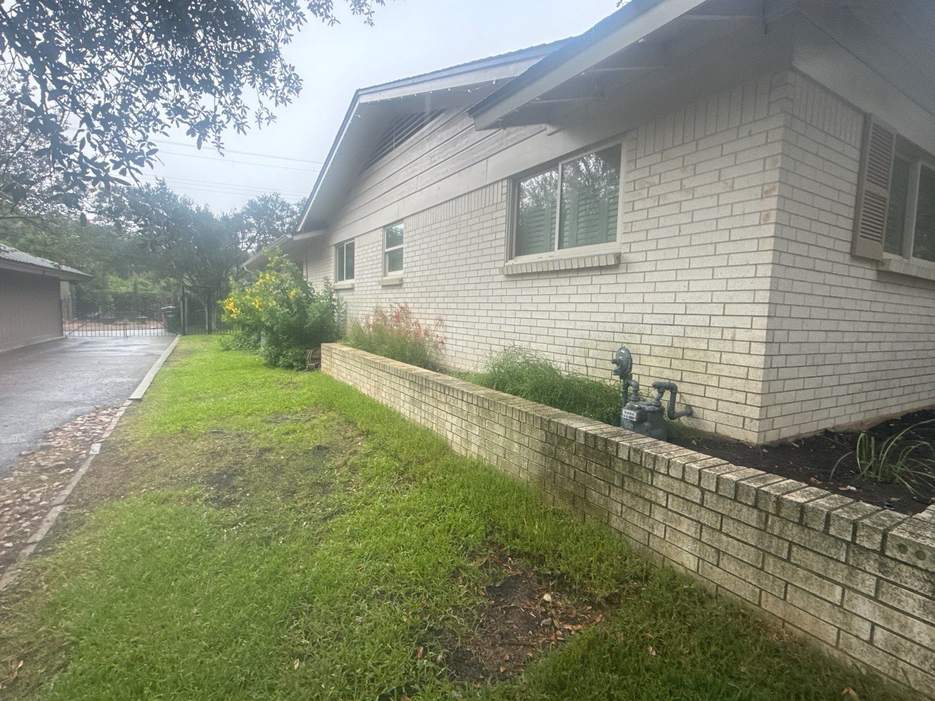 Side exterior brick wall of the home ahead of painting