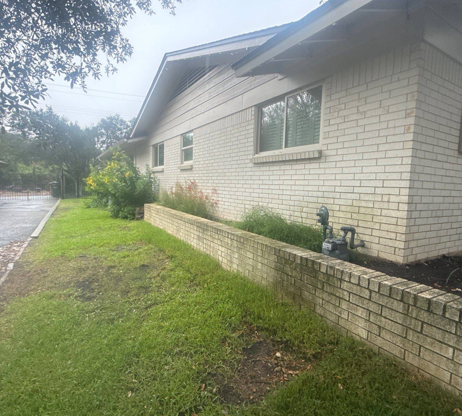 Side exterior brick wall of the home ahead of painting