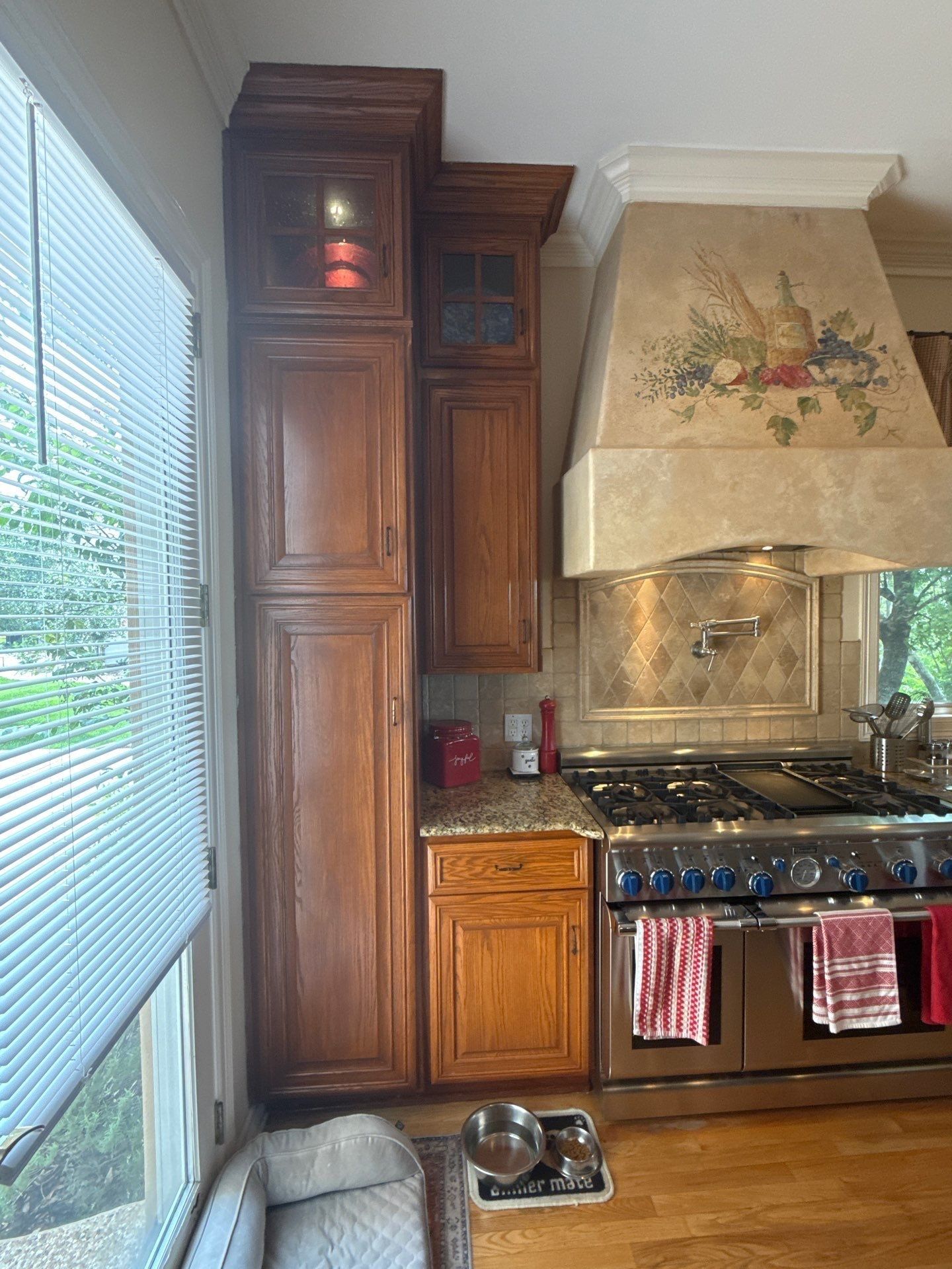 Tall pantry cabinets with glass-front uppers ahead of painting