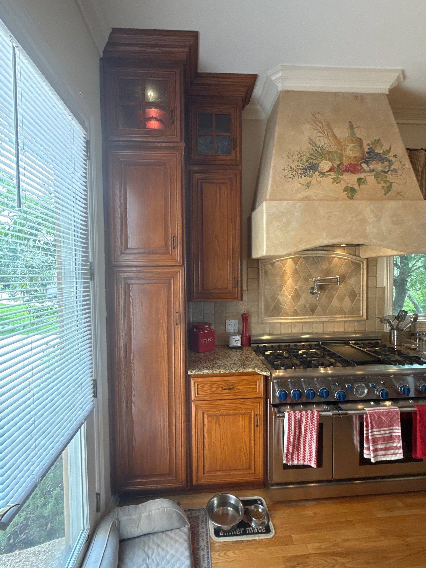 Tall pantry cabinets with glass-front uppers ahead of painting