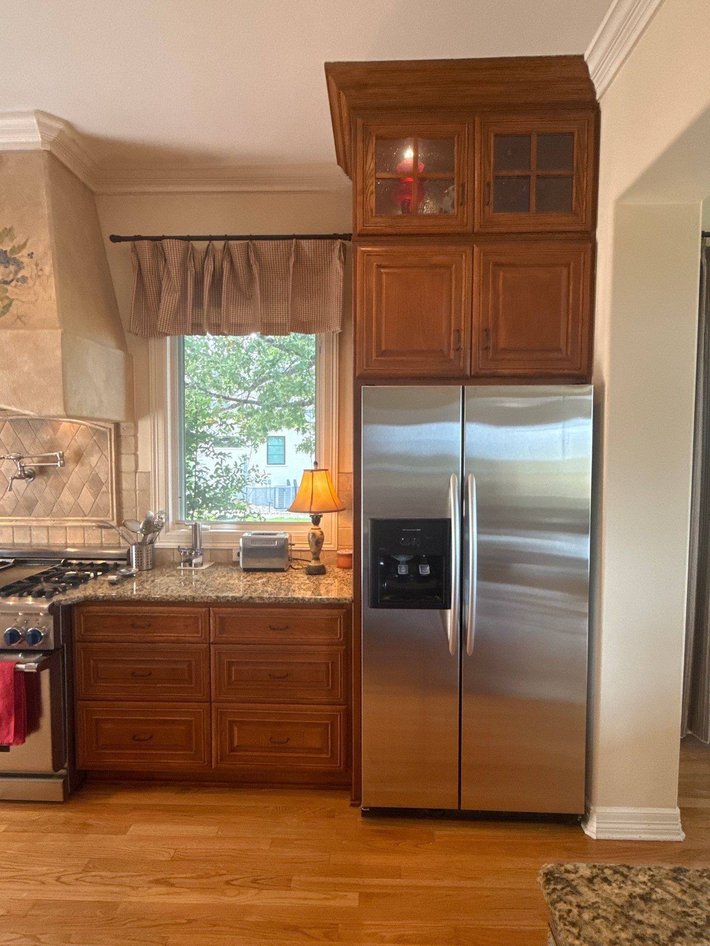 Cabinets surrounding the refrigerator ahead of painting