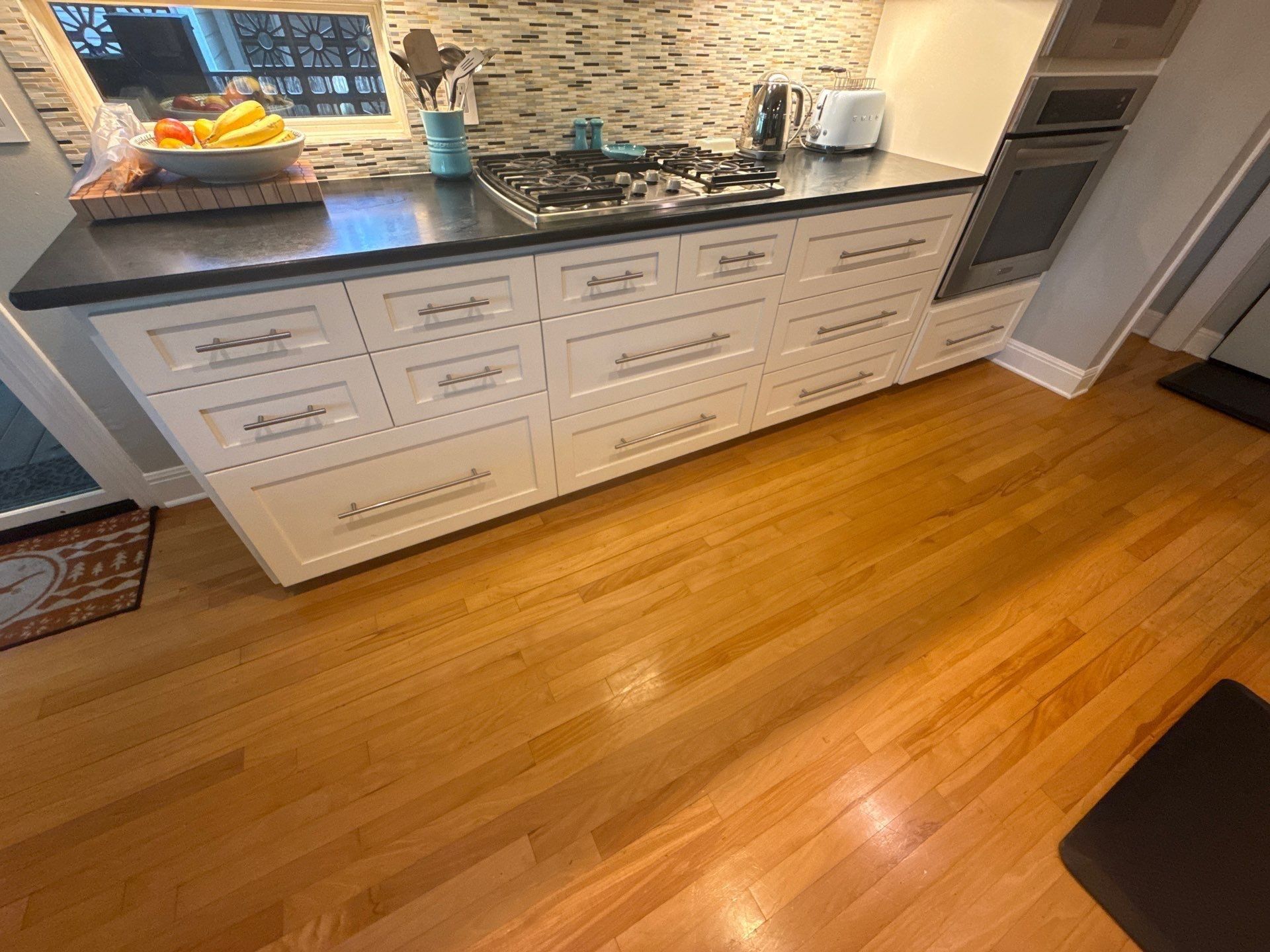 Row of kitchen cabinet drawers and appliances ahead of painting