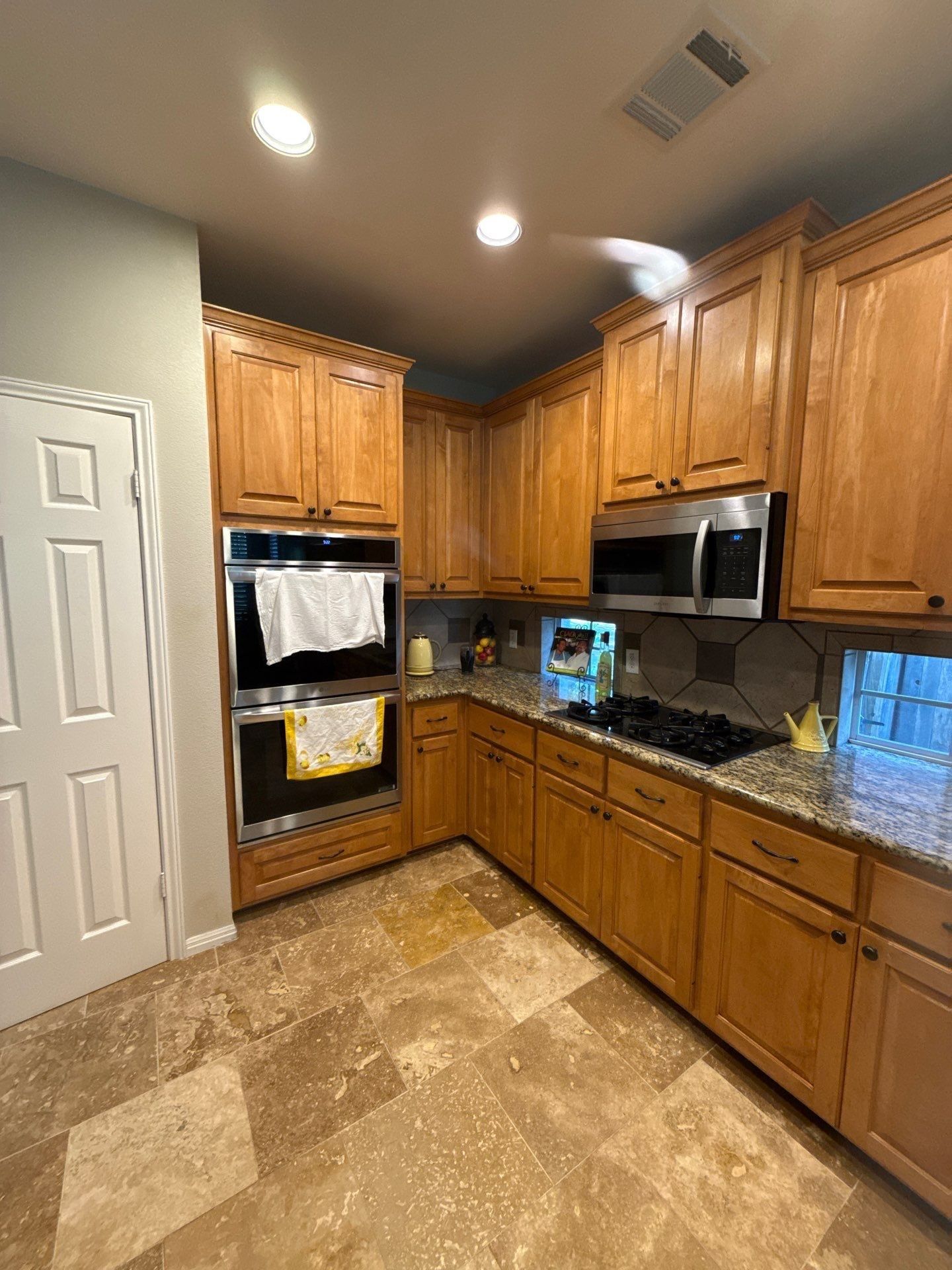 Kitchen cabinets, double ovens, and microwave ahead of painting