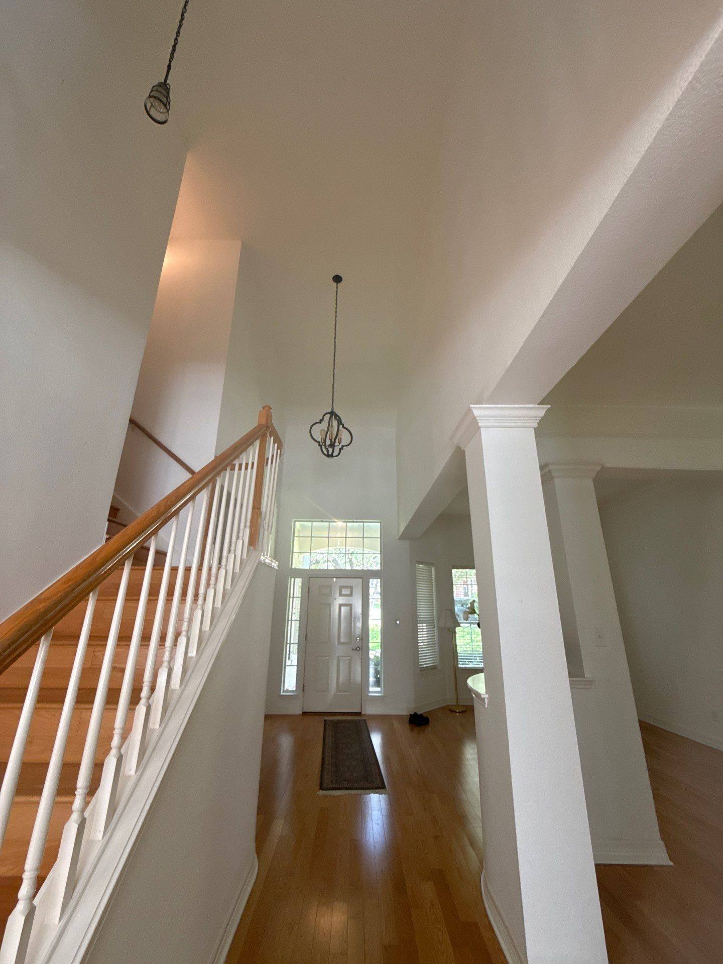 Two-story entry foyer with front door and staircase